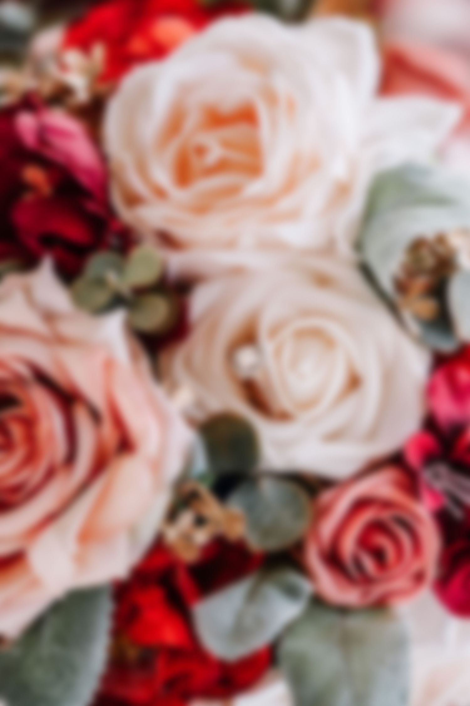 Beautiful arrangement of blush pink and red roses with delicate floral details.