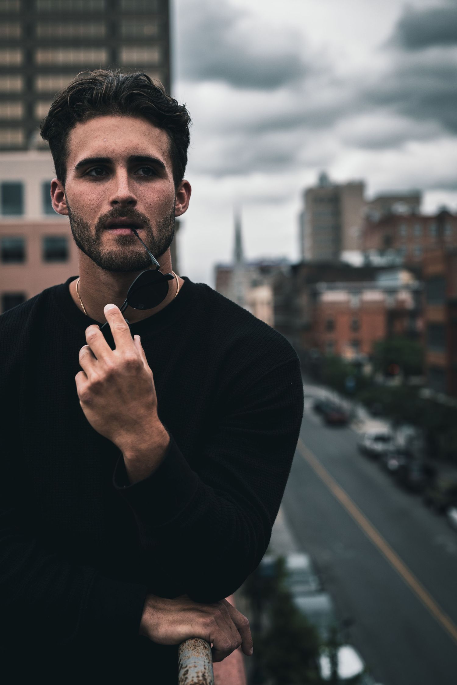Urban photography sequence showing a person in black clothing against a cloudy city backdrop.