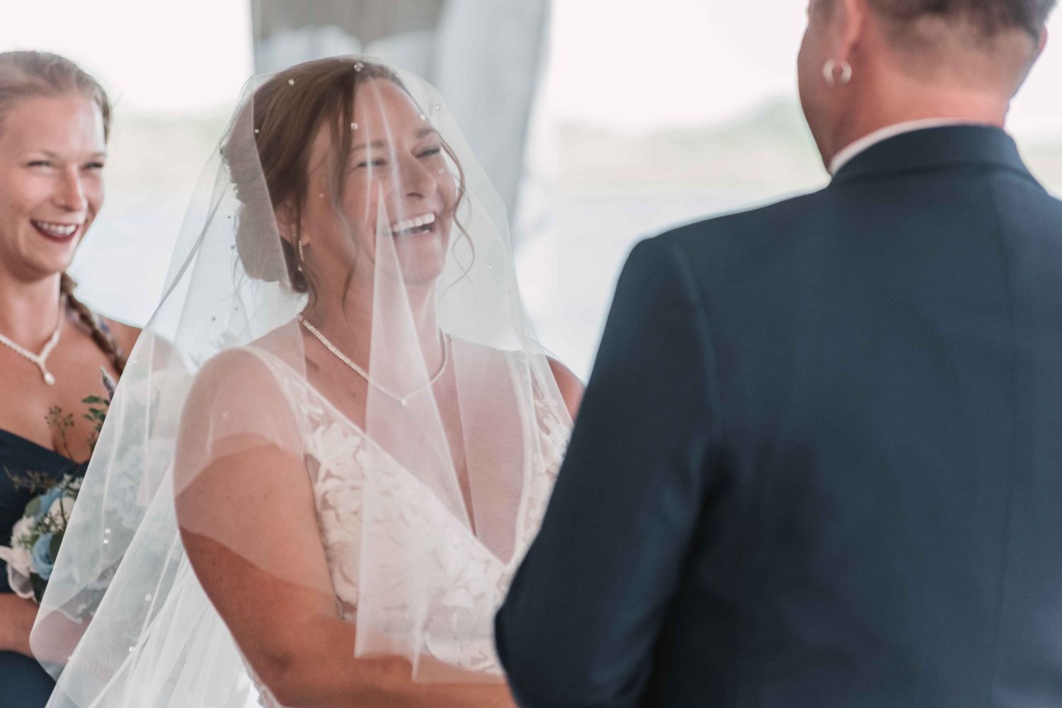 Wedding party shares emotional reactions during an indoor ceremony.