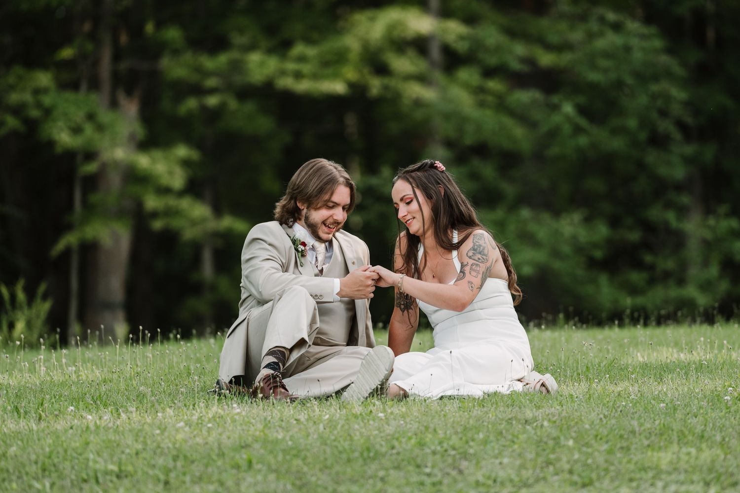 Intimate wedding photos taken on a grassy hillside surrounded by trees.