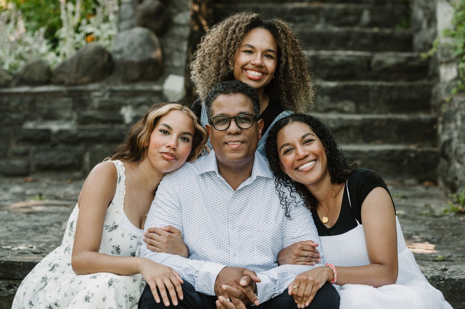 A joyful family portrait taken outdoors on stone steps.