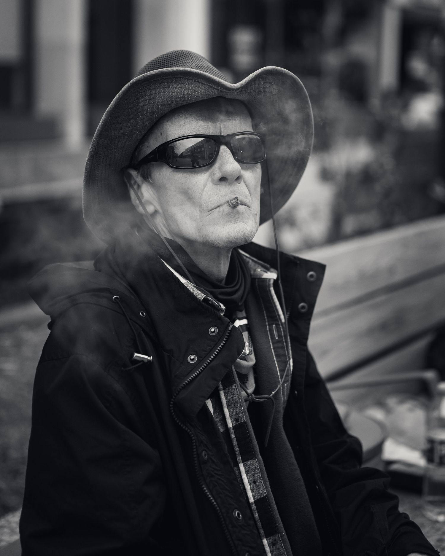 Dramatic black and white portrait of person in hat and sunglasses.