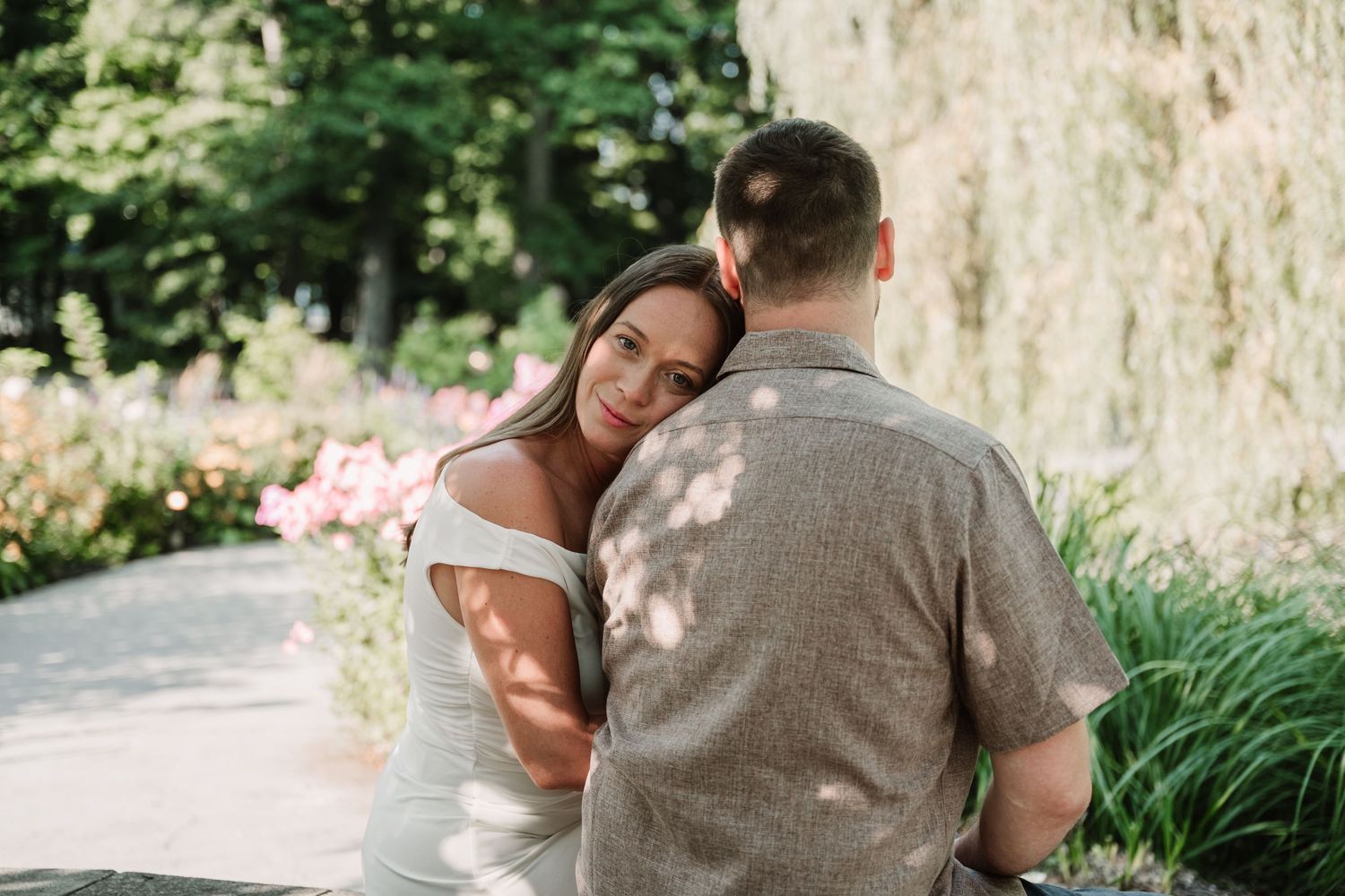 Romantic engagement photos taken in a lush garden setting.