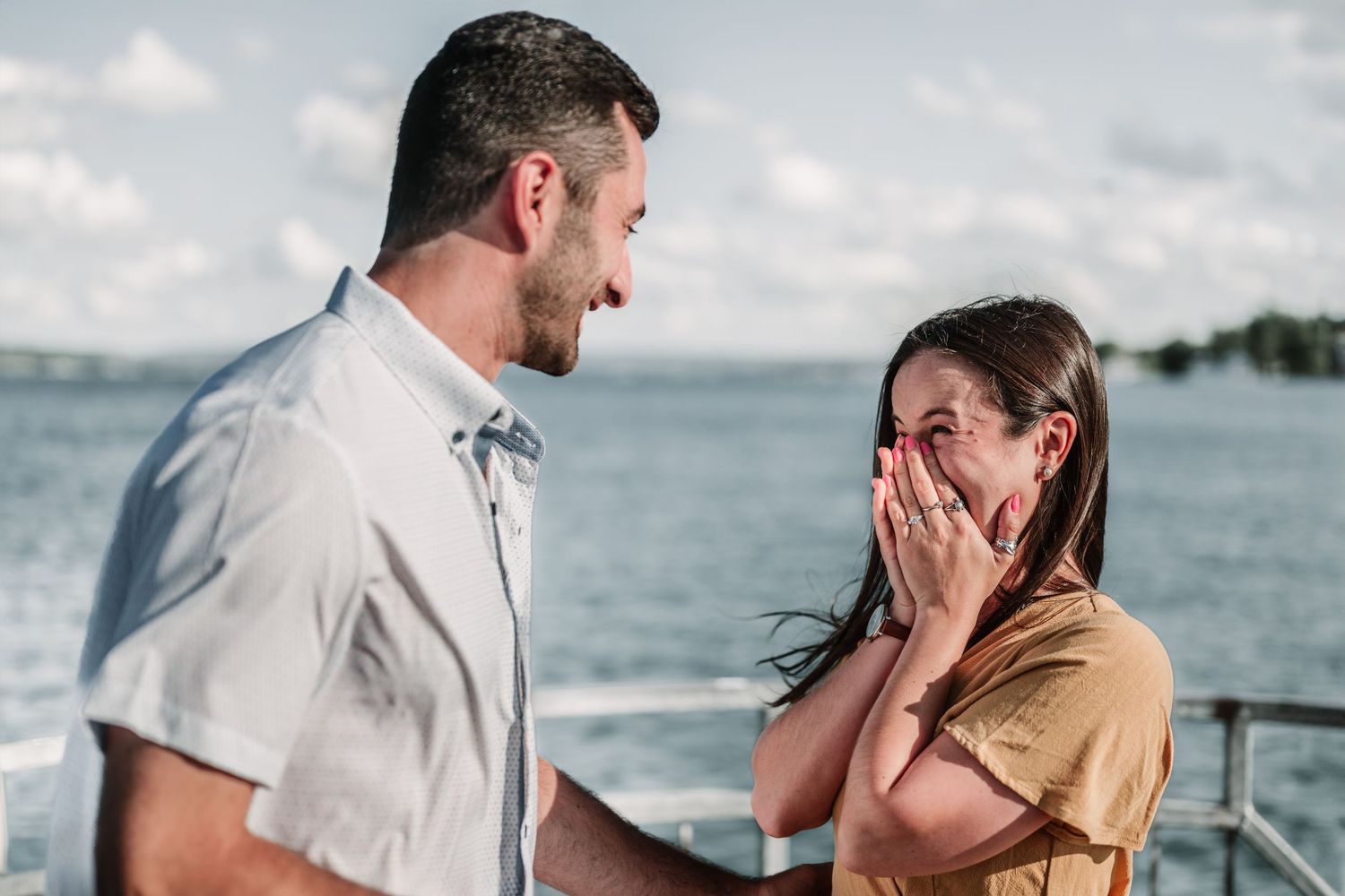 A couple shares tender moments during a seaside proposal with ocean views.