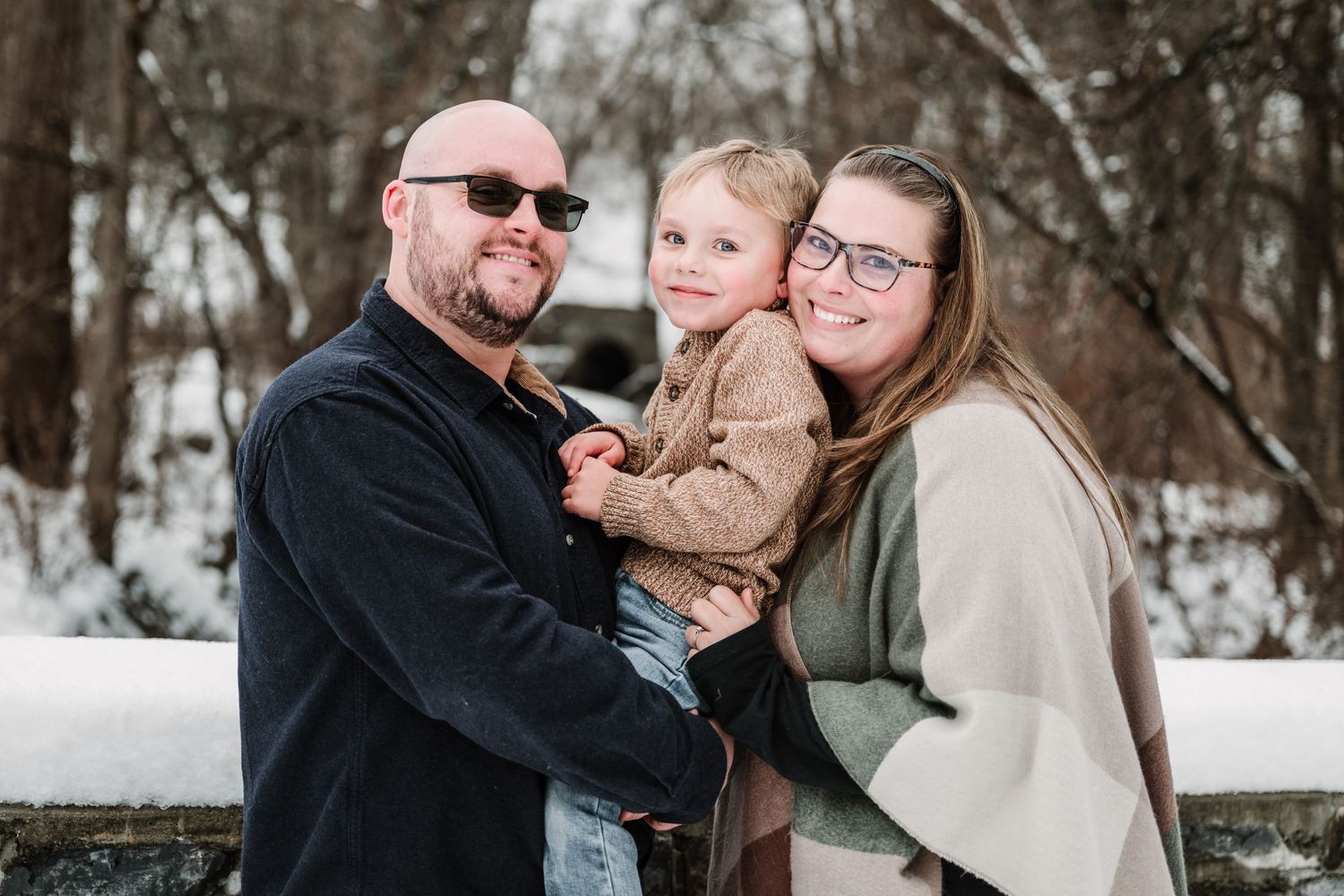 Family sharing joyful moments together during winter photo session in the snow.