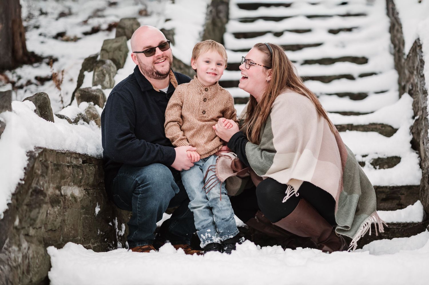 Family portrait in snowy setting with everyone bundled in winter coats.
