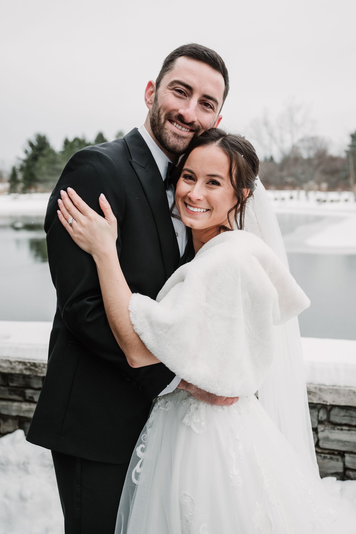 Winter wedding couple shares romantic moments against snowy backdrop.