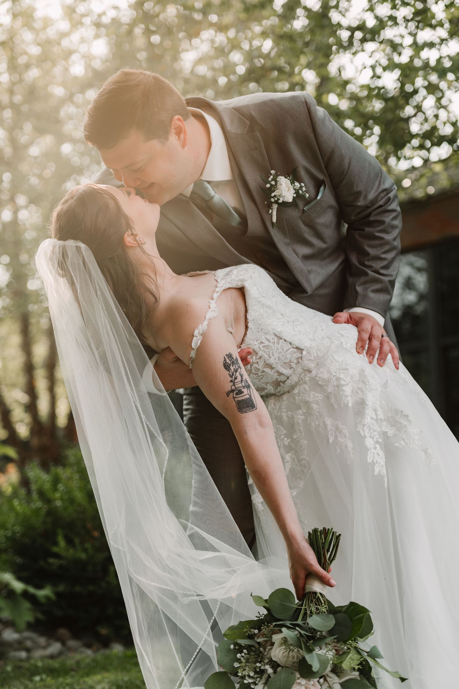 Romantic wedding poses captured in golden sunlight with flowing veil details.