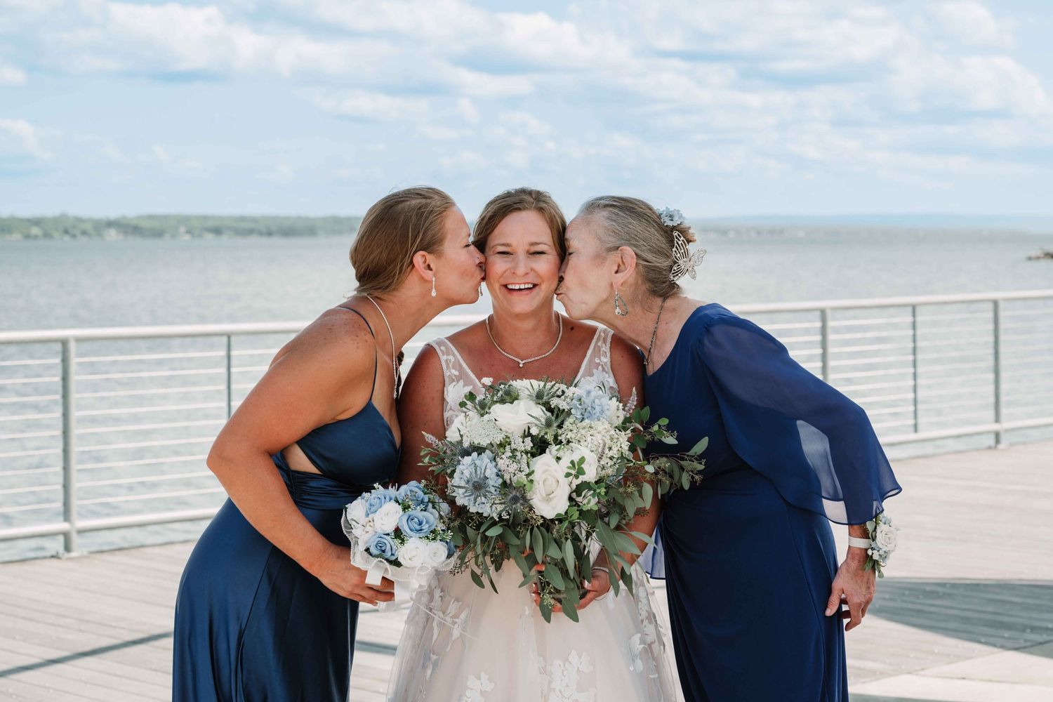 Wedding party members share joyful moments together by the ocean.