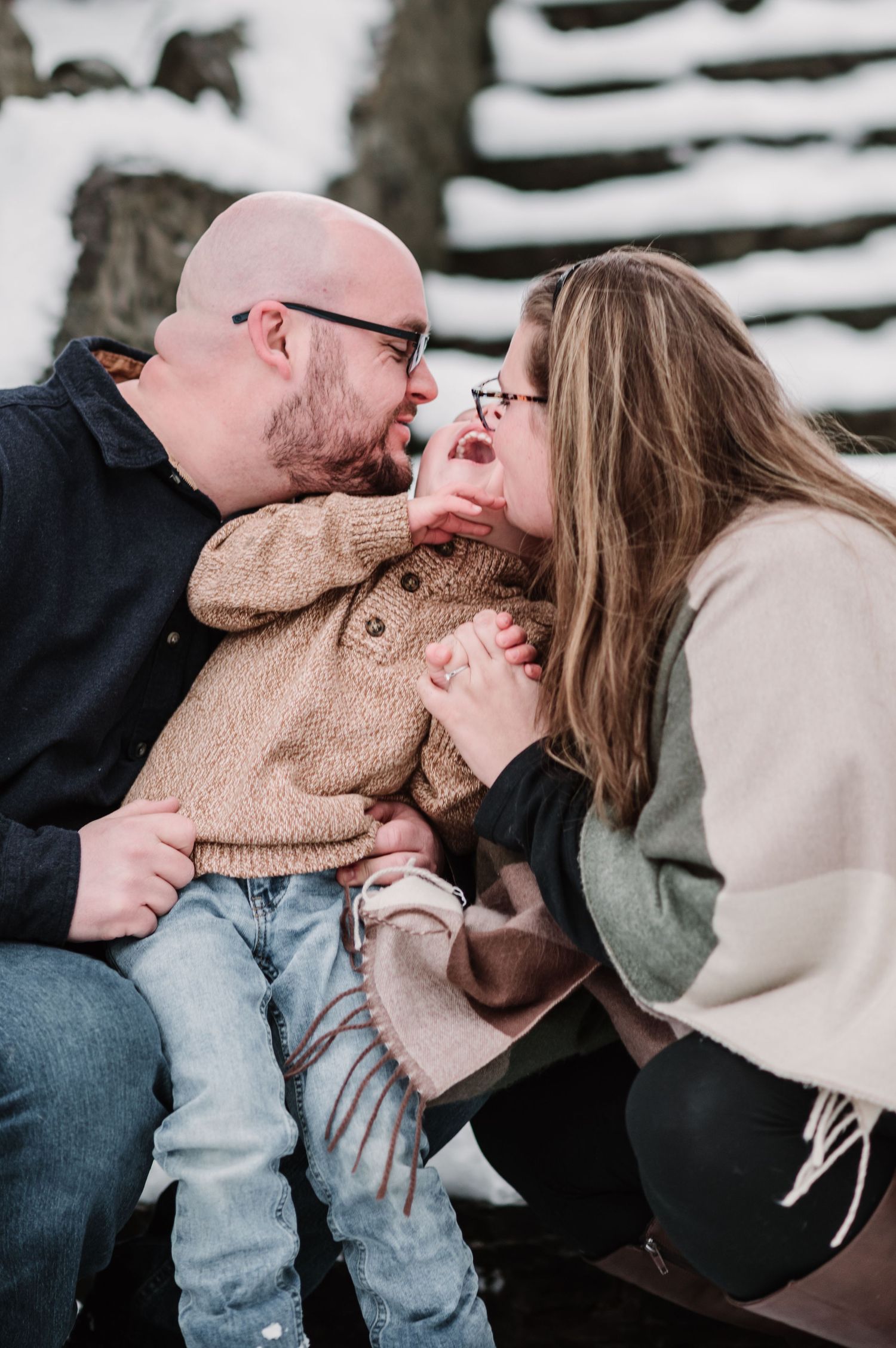 A cozy winter moment between a couple in warm sweaters against a snowy backdrop.