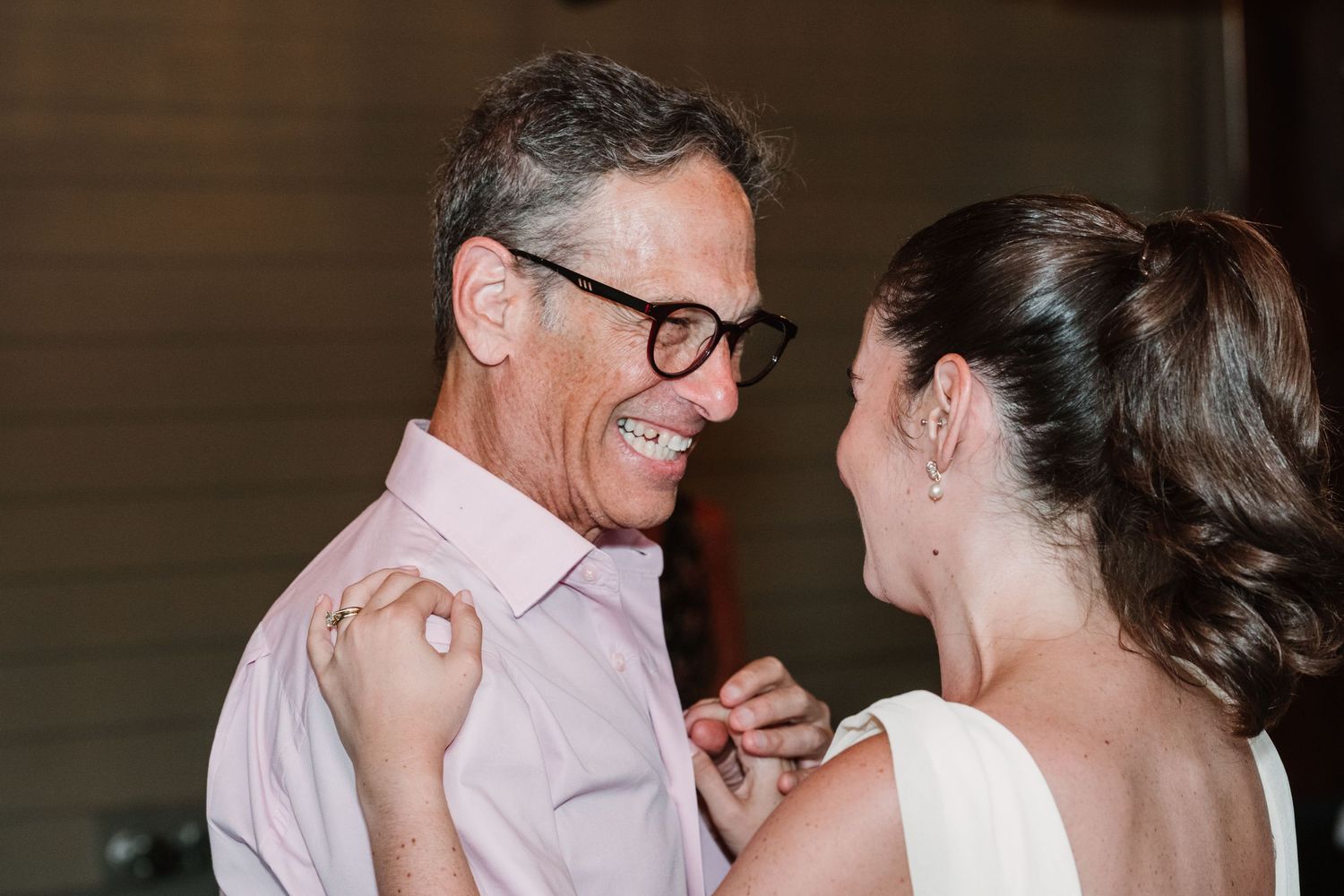 A joyful dance between two wedding attendees in formal attire.
