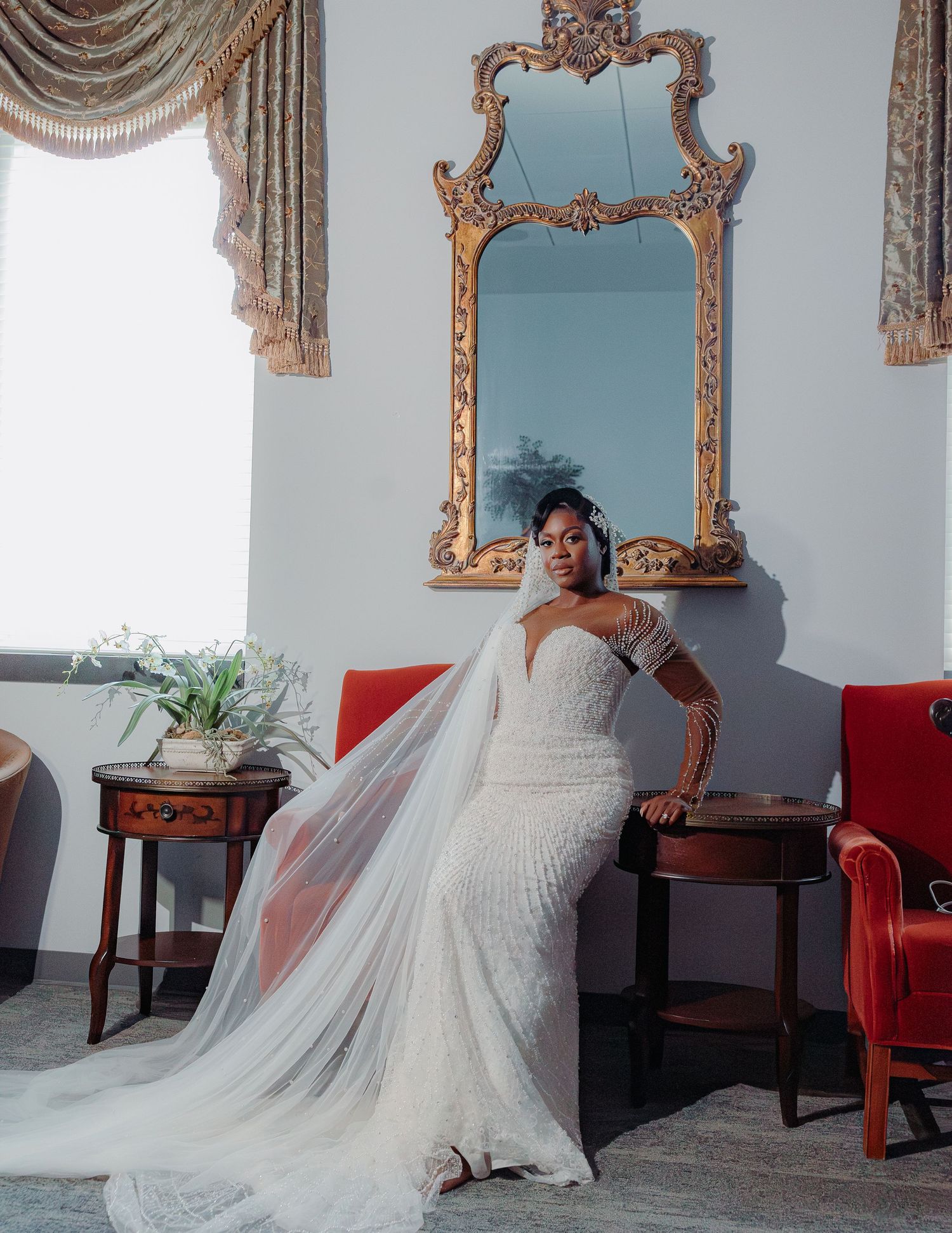 Ornate gold mirror frames and elegant decor surround a flowing white wedding gown.