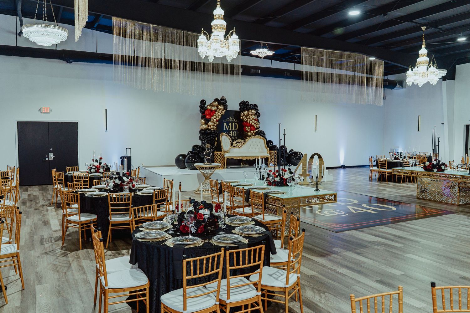 A panoramic view of a large warehouse space with scattered furniture and equipment arranged throughout the area.