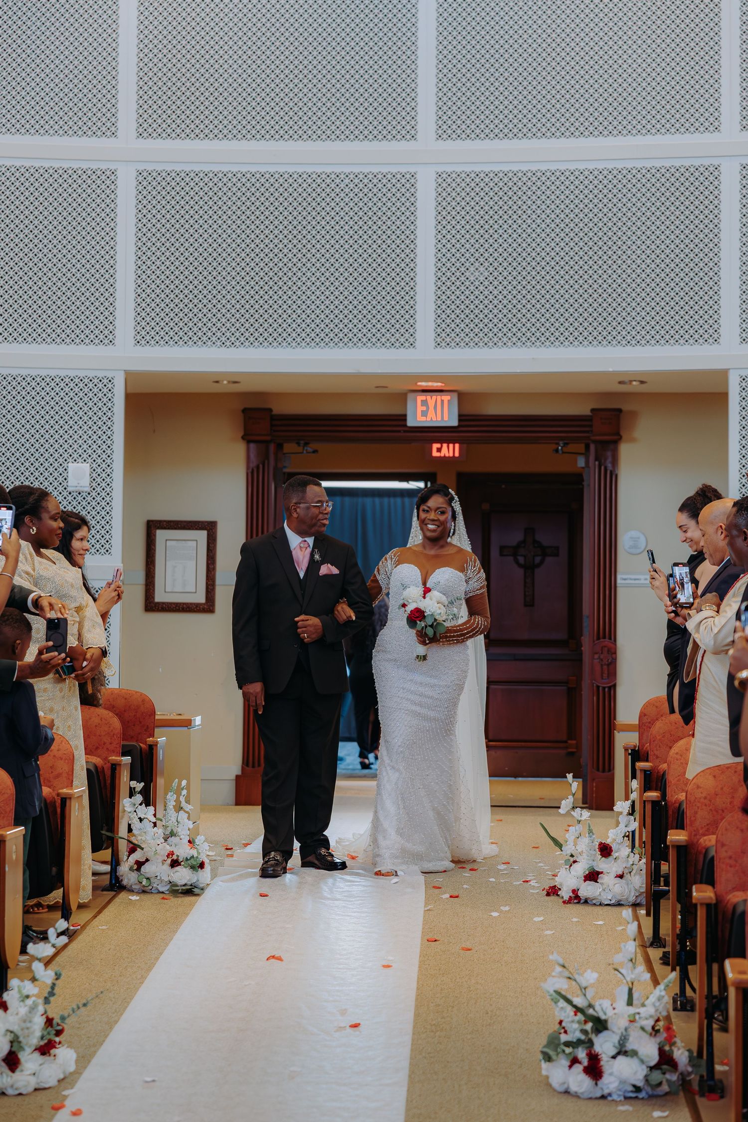 Wedding ceremony aisle decorated with rose petals in an elegant indoor venue.