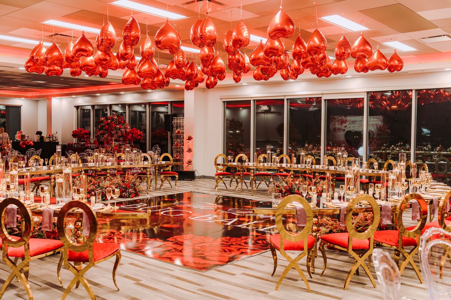 Modern fitness studio with red lighting and rows of stationary bikes arranged for a spin class workout session.