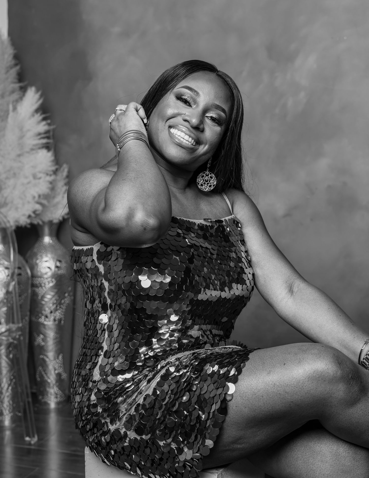 Black and white artistic portrait series showing graceful poses in a sequined dress against a textured background.