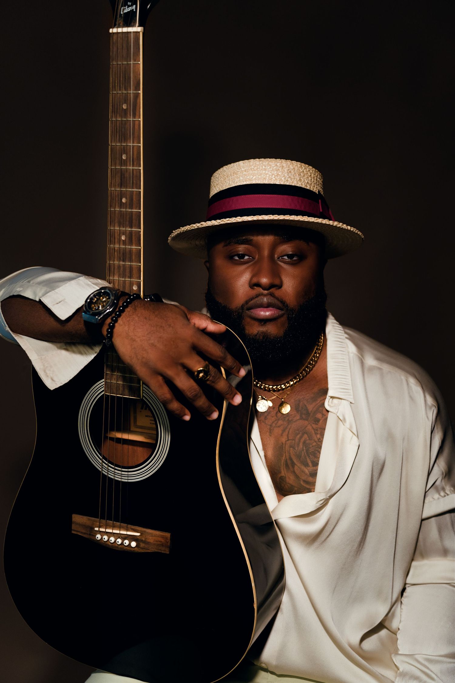 Moody portrait series featuring acoustic guitar and straw hat against dark background.