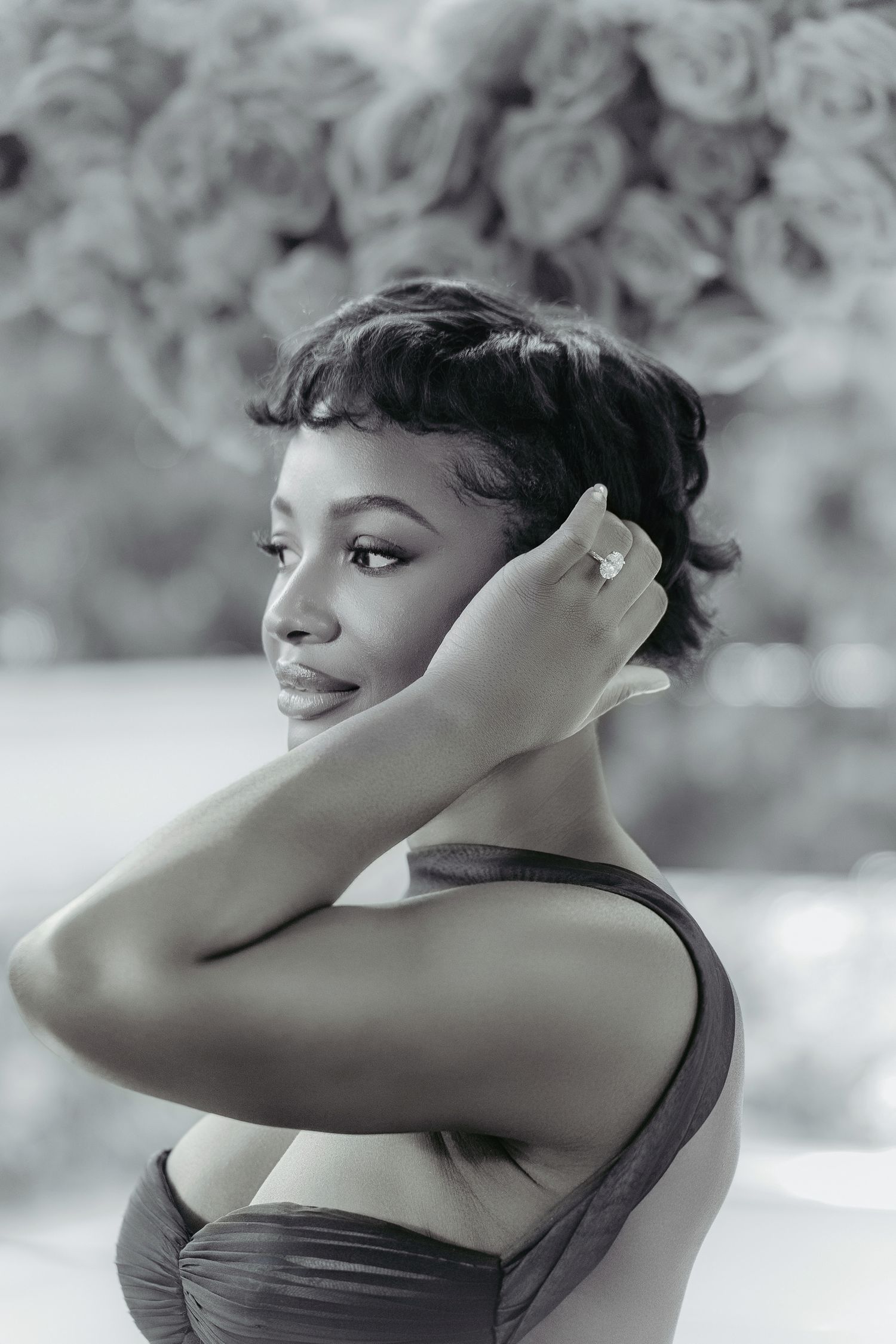 Elegant black and white portrait of a woman in vintage style with short curled hair and delicate jewelry.