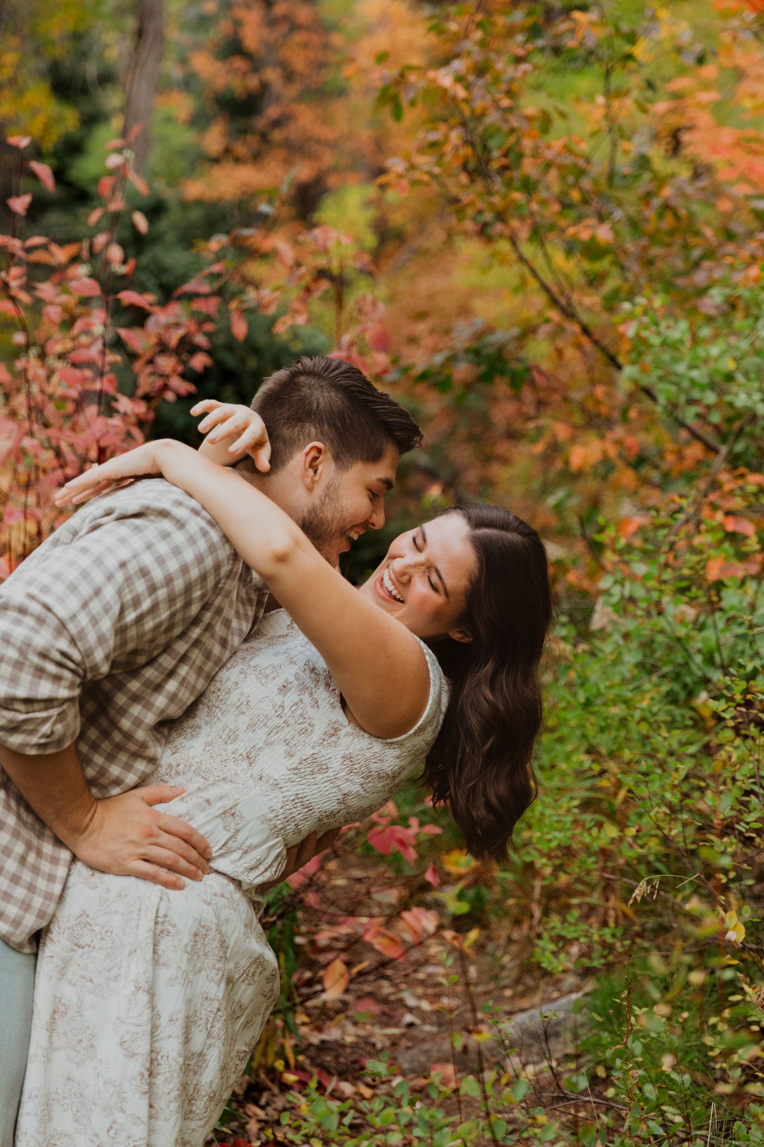 Romantic autumn engagement photos with couple embracing among fall foliage Tibble Fork Utah County