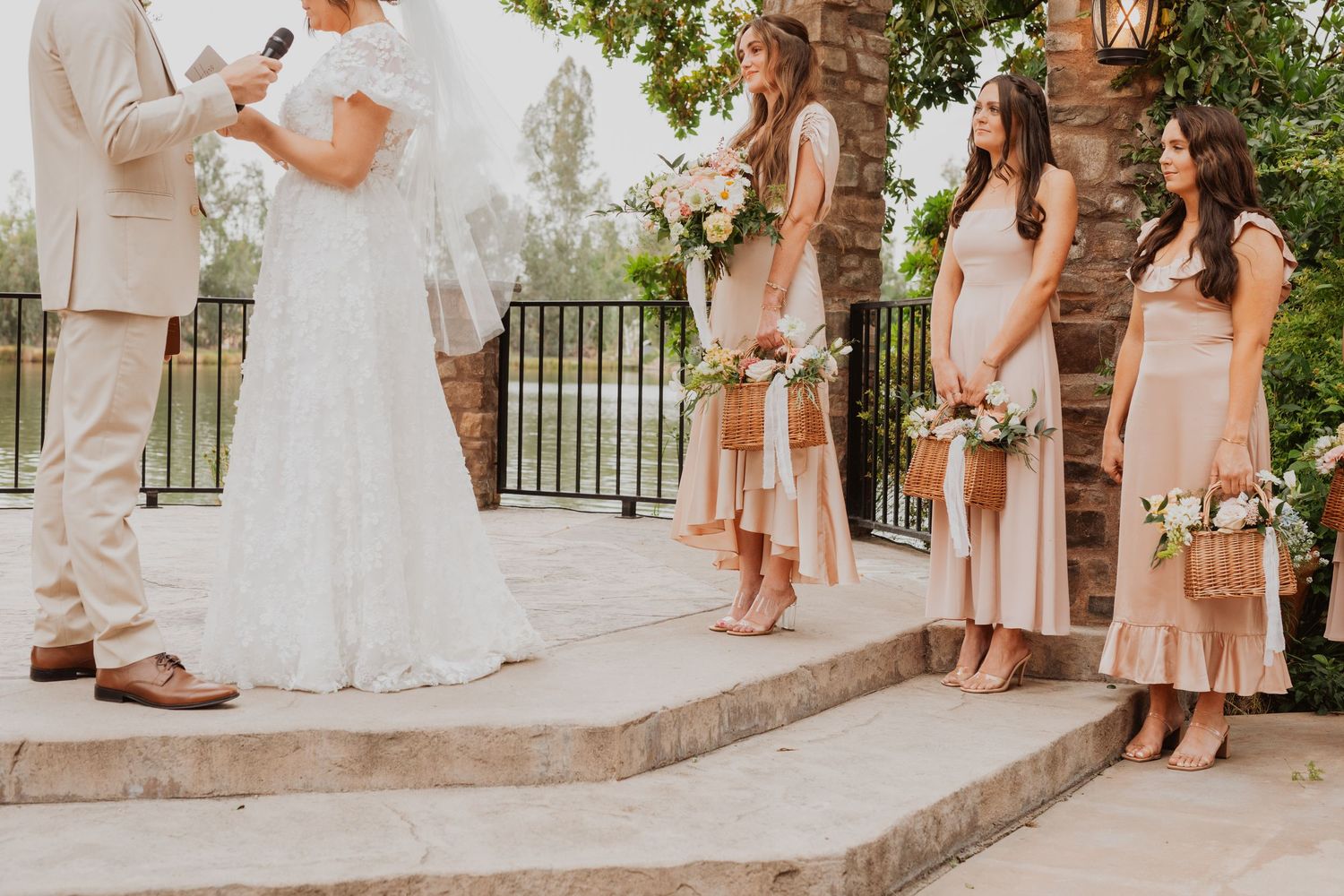 Wedding celebration on stone patio with floral arrangements and wooden pergola overhead.