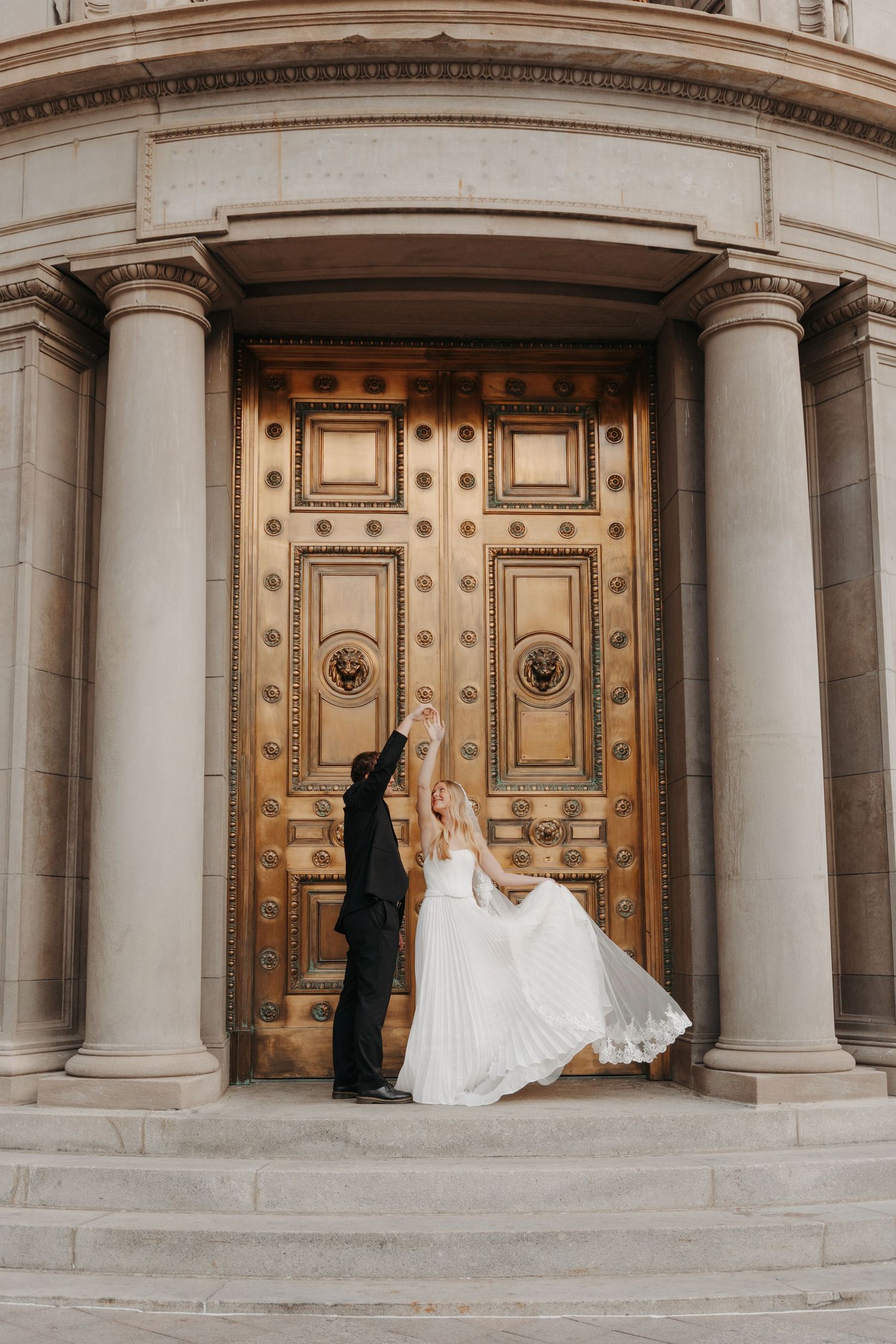 Elegant wedding couple poses in sequence against grand historic building with ornate columns and golden doors.