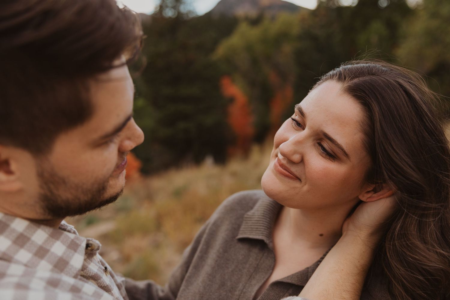 A couple shares an intimate moment during a golden hour photoshoot.