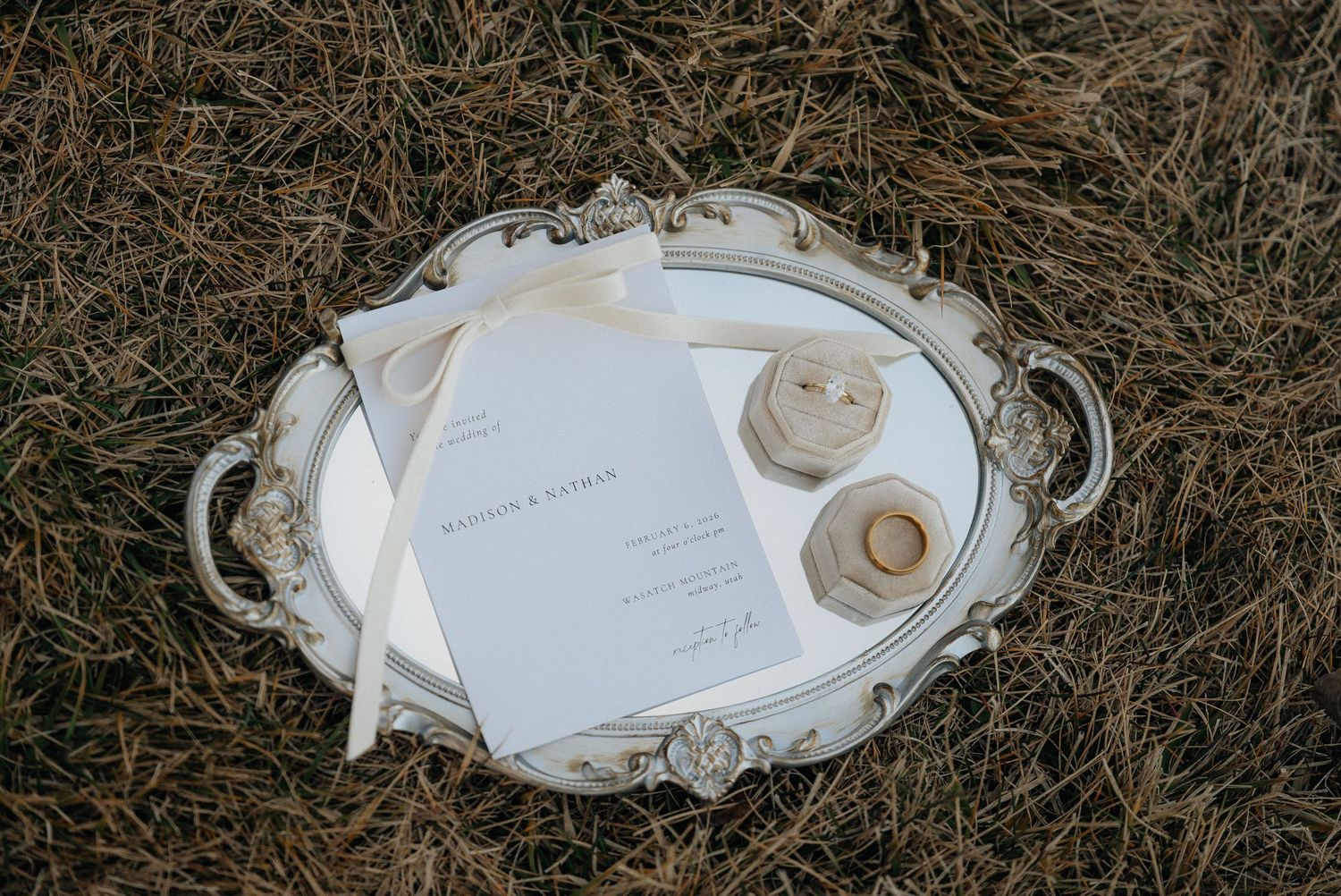 Wedding stationery and invitation details arranged artistically on dried grass in Utah.