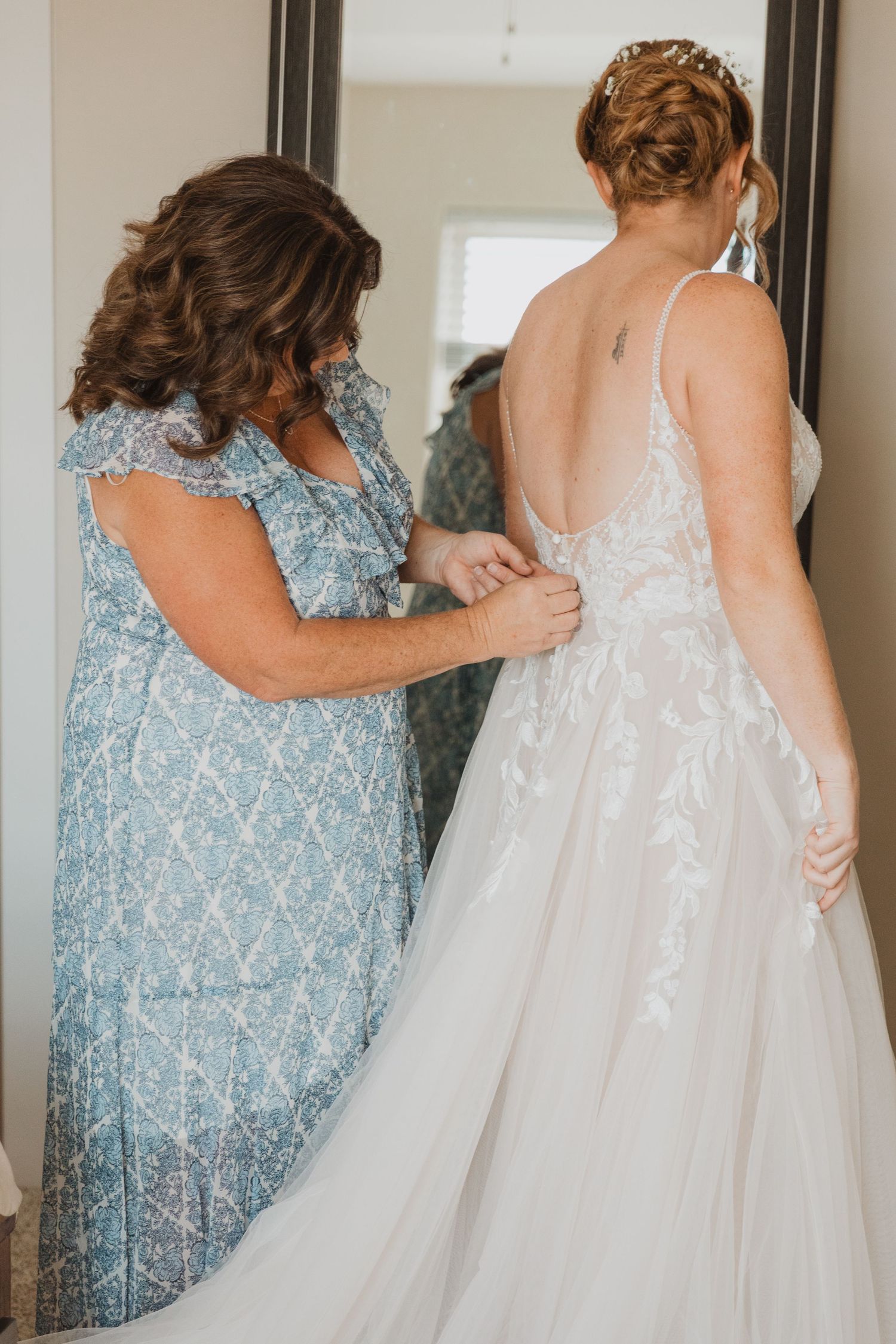 Close-up shots of bridesmaids helping with the wedding dress details.