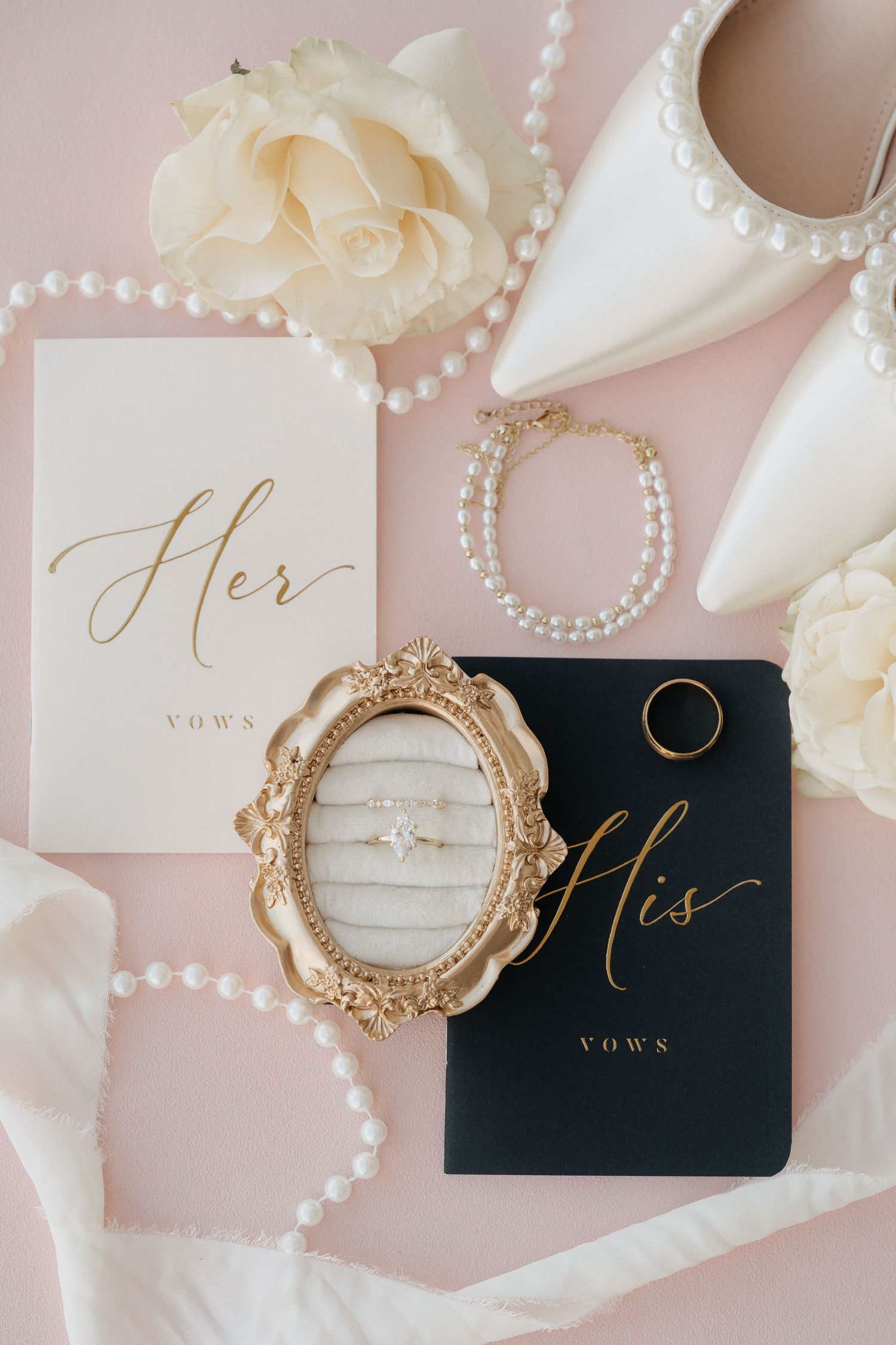 Utah Wedding vow books with gold lettering and pearl decorations on a soft pink background.