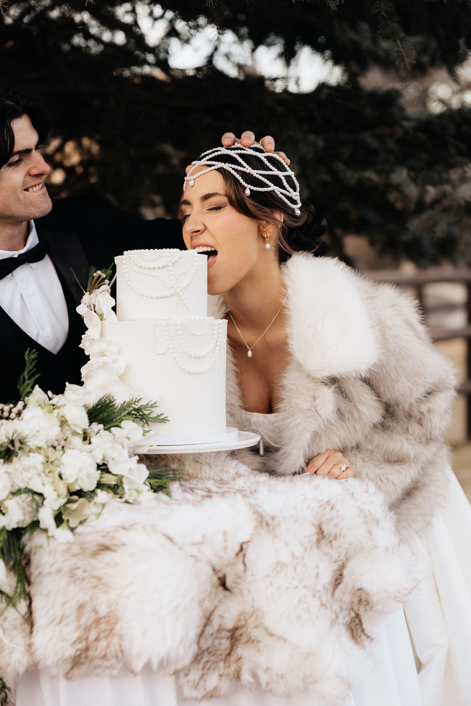 Wedding celebration with white fur wrap and elegant cake in an outdoor setting in Utah