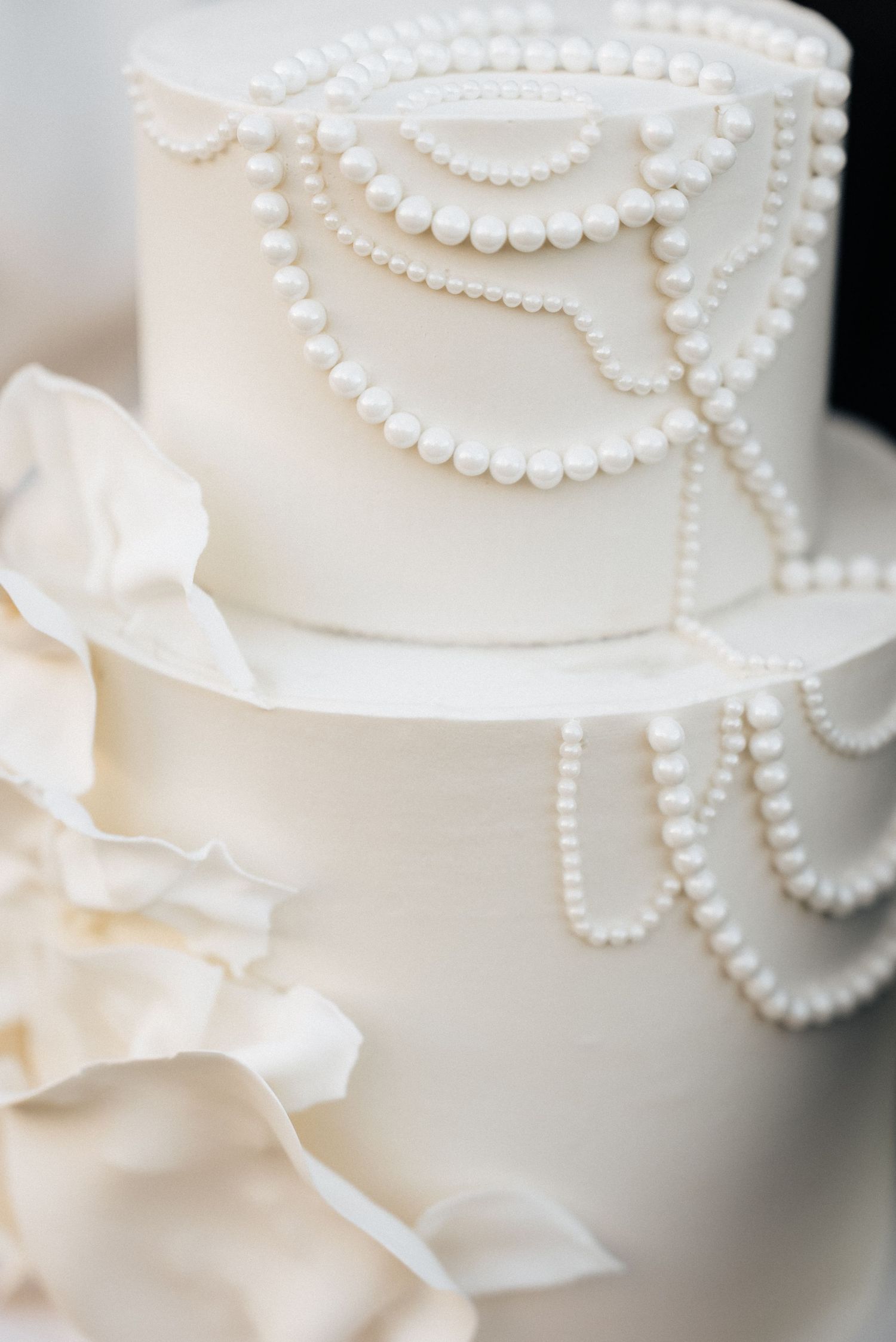Elegant white wedding cake decorated with delicate pearl details and floral accents in Utah.