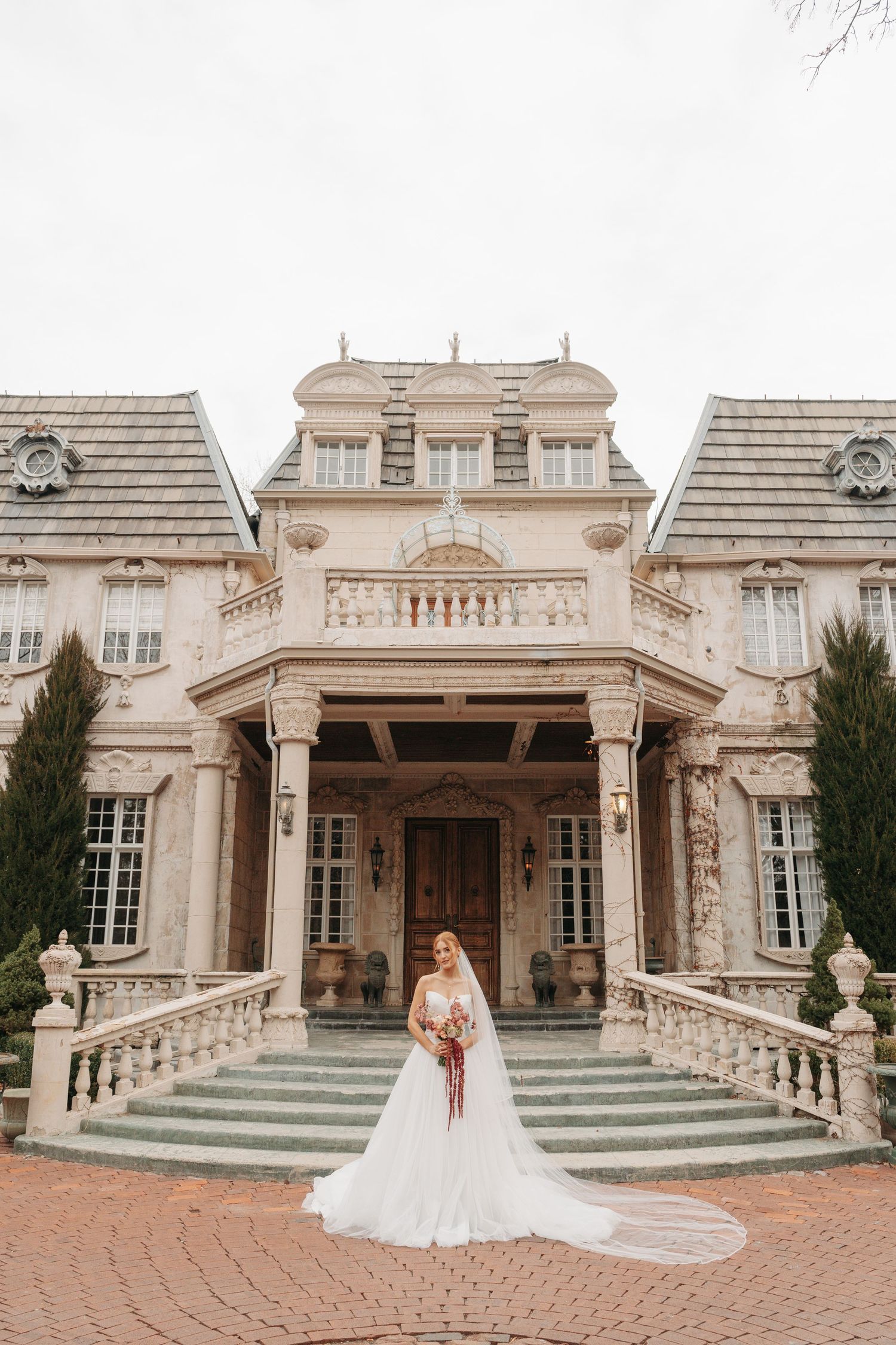 Elegant French chateau style mansion with grand stone steps and ornate architectural details in beige stone.