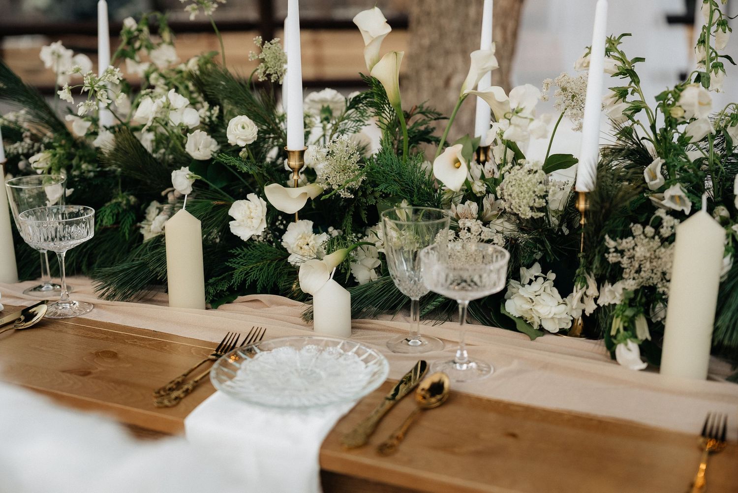 Elegant white floral table setting with candles and glassware for a wedding reception in Utah.