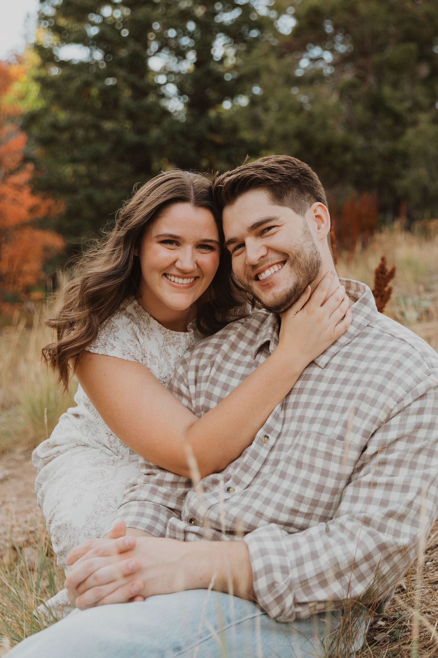 Playful engagement session in fall setting with couple in casual attire Tibble Fork Utah County