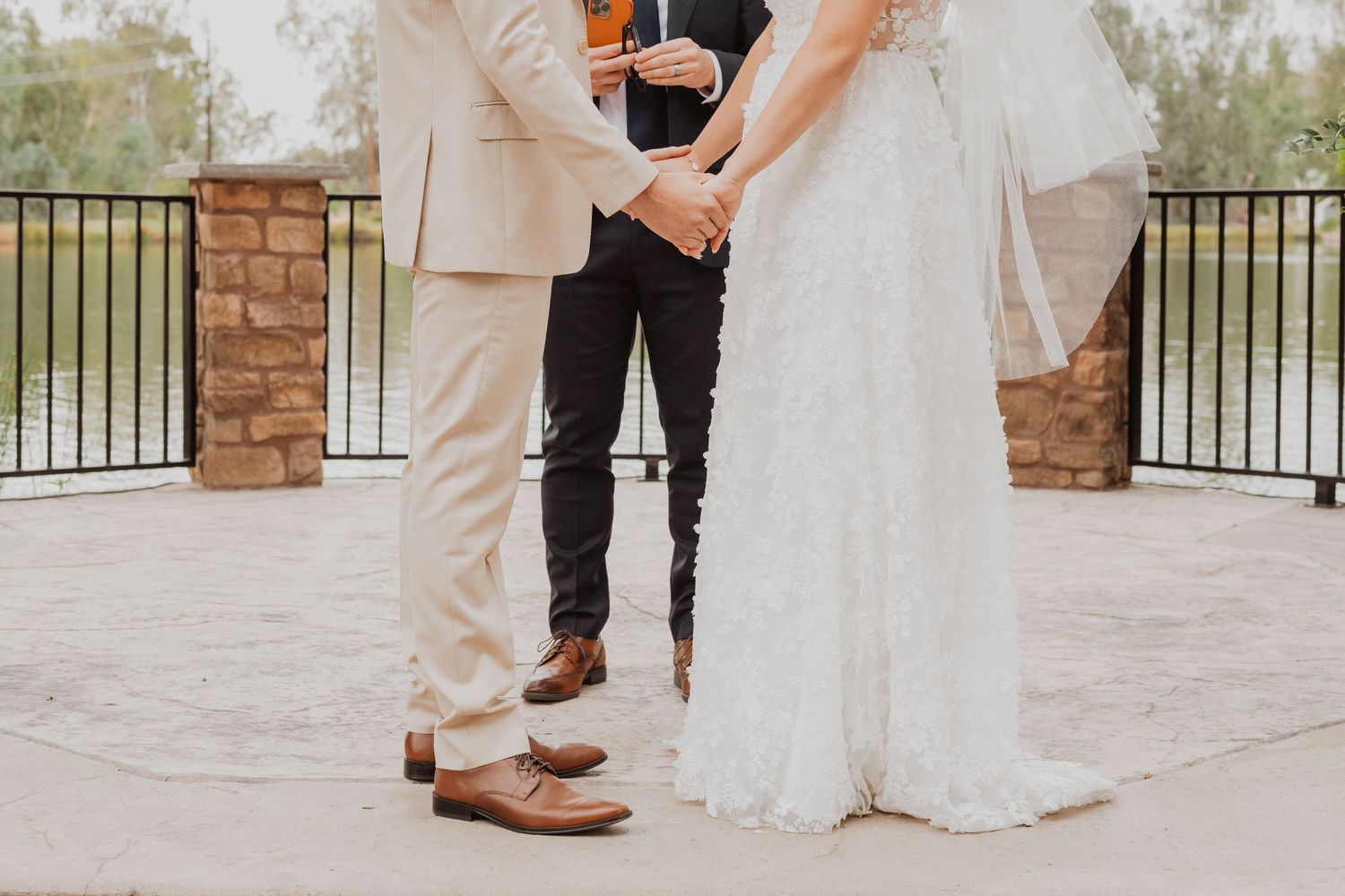Formal wedding ceremony moments captured on stone patio with decorative railings.