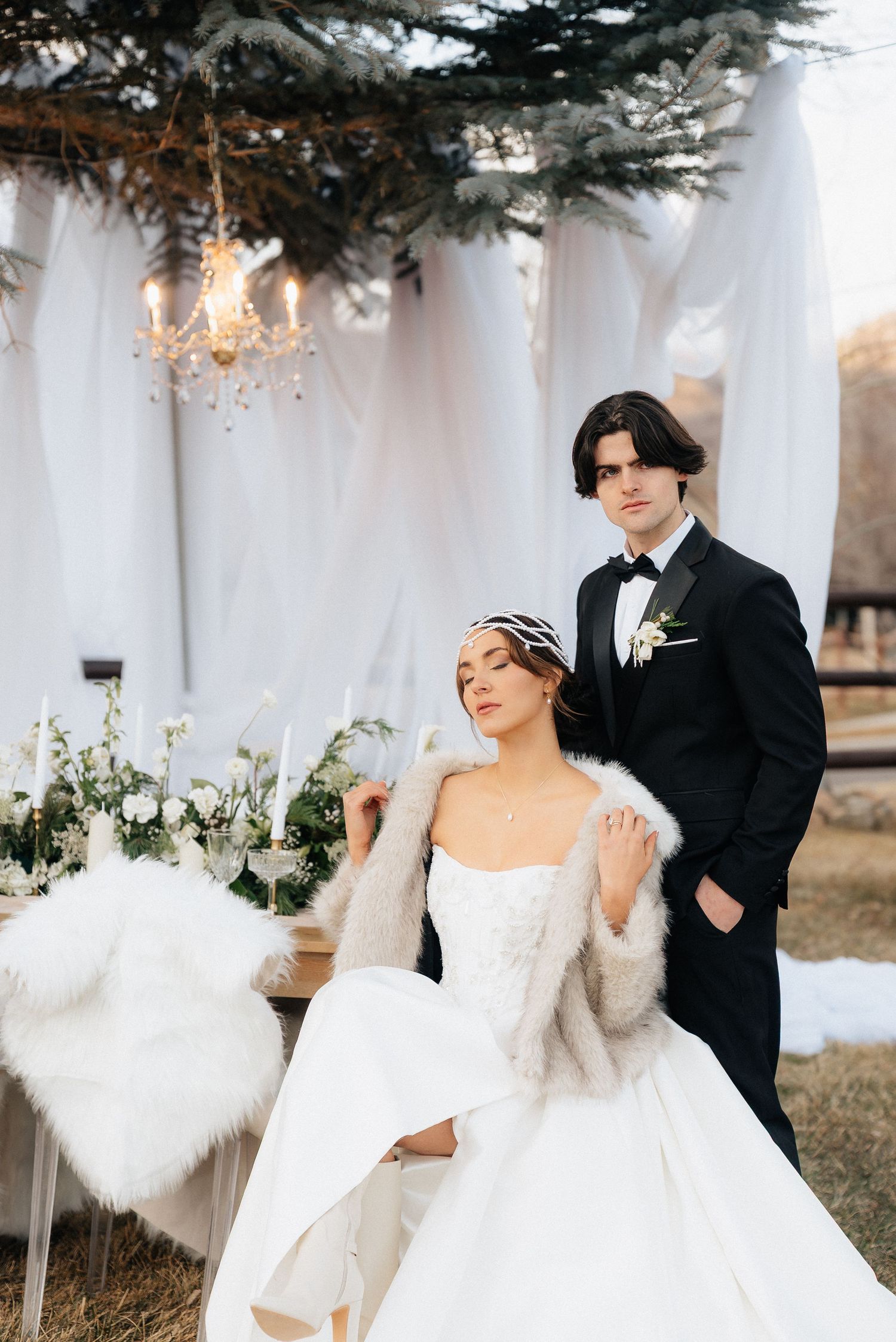 Winter wedding ceremony setup with white drapes and evergreen decorations outdoors in Utah.
