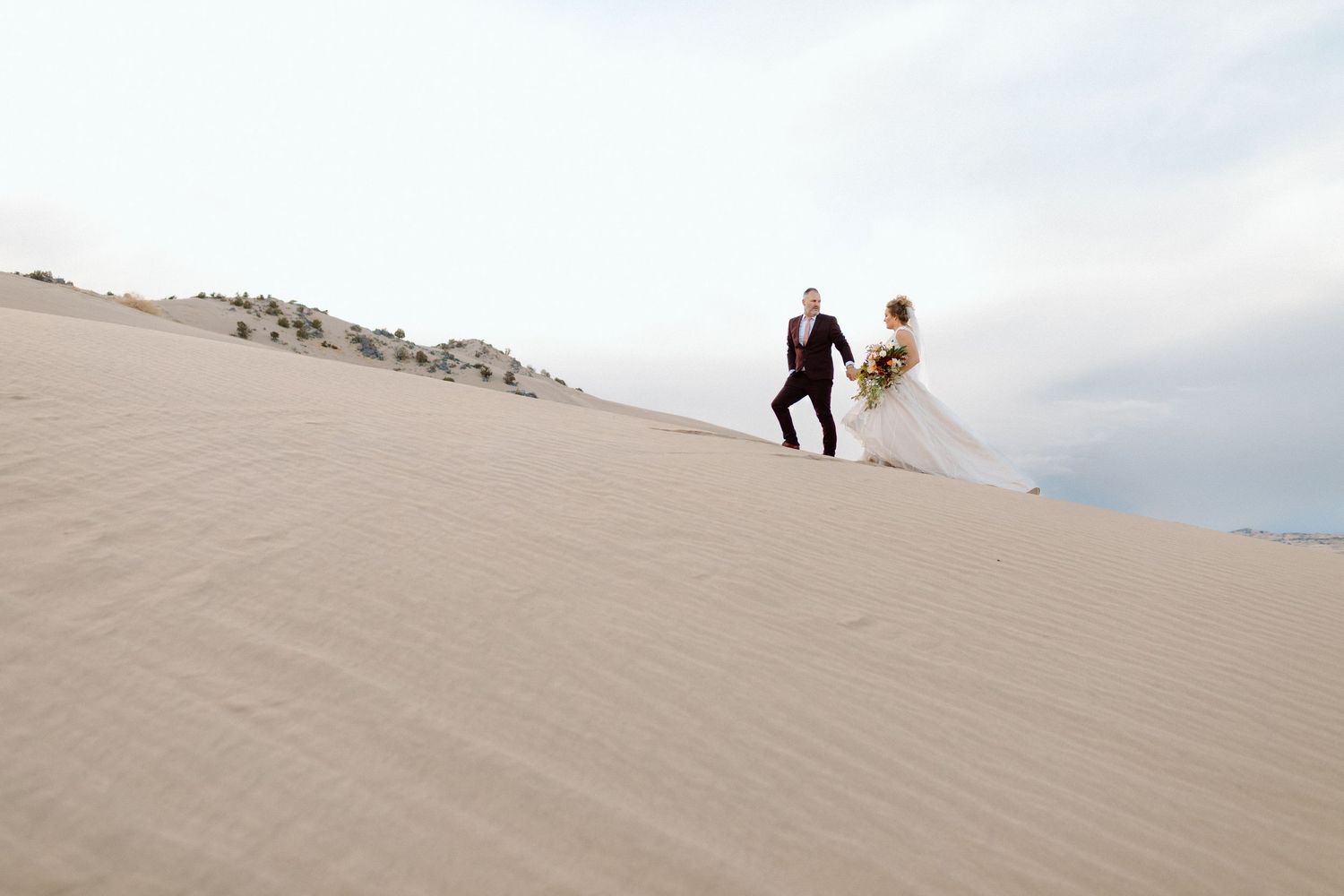 Wedding Couple getting bridal photos done at the Little Sahara Sand dunes in Utah