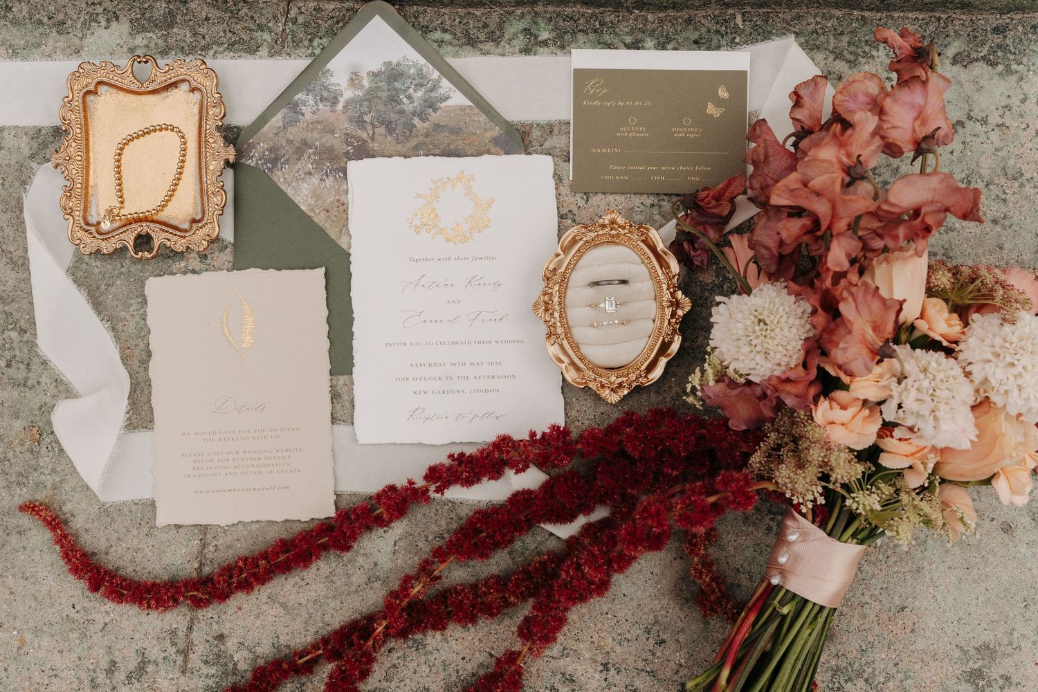 Elegant wedding invitation suite with rose gold frames and coral floral accents displayed alongside a romantic bouquet.