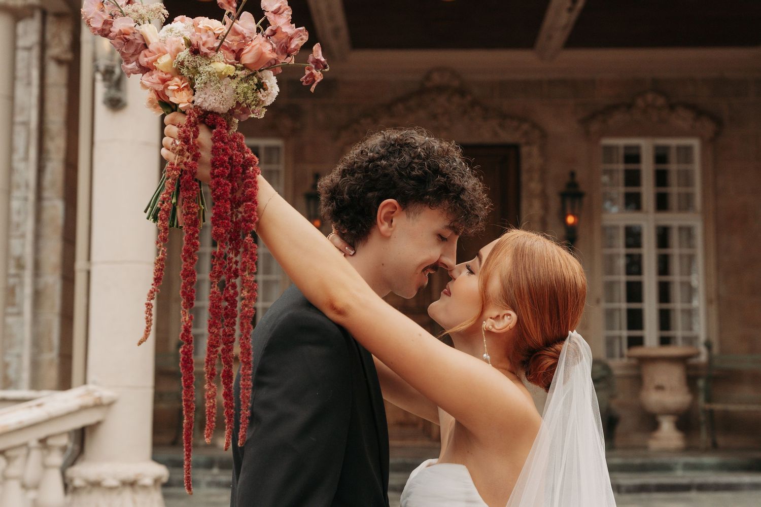 A happy couple in wedding attire shares a joyful moment together during their outdoor celebration.