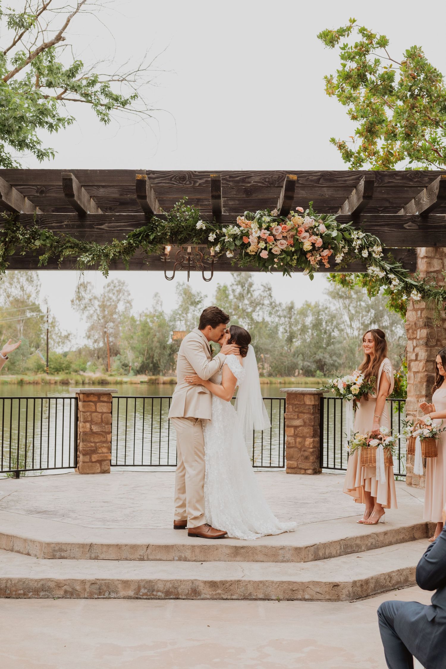 Wedding ceremony candid moments captured on an outdoor stone patio with wooden pergola.