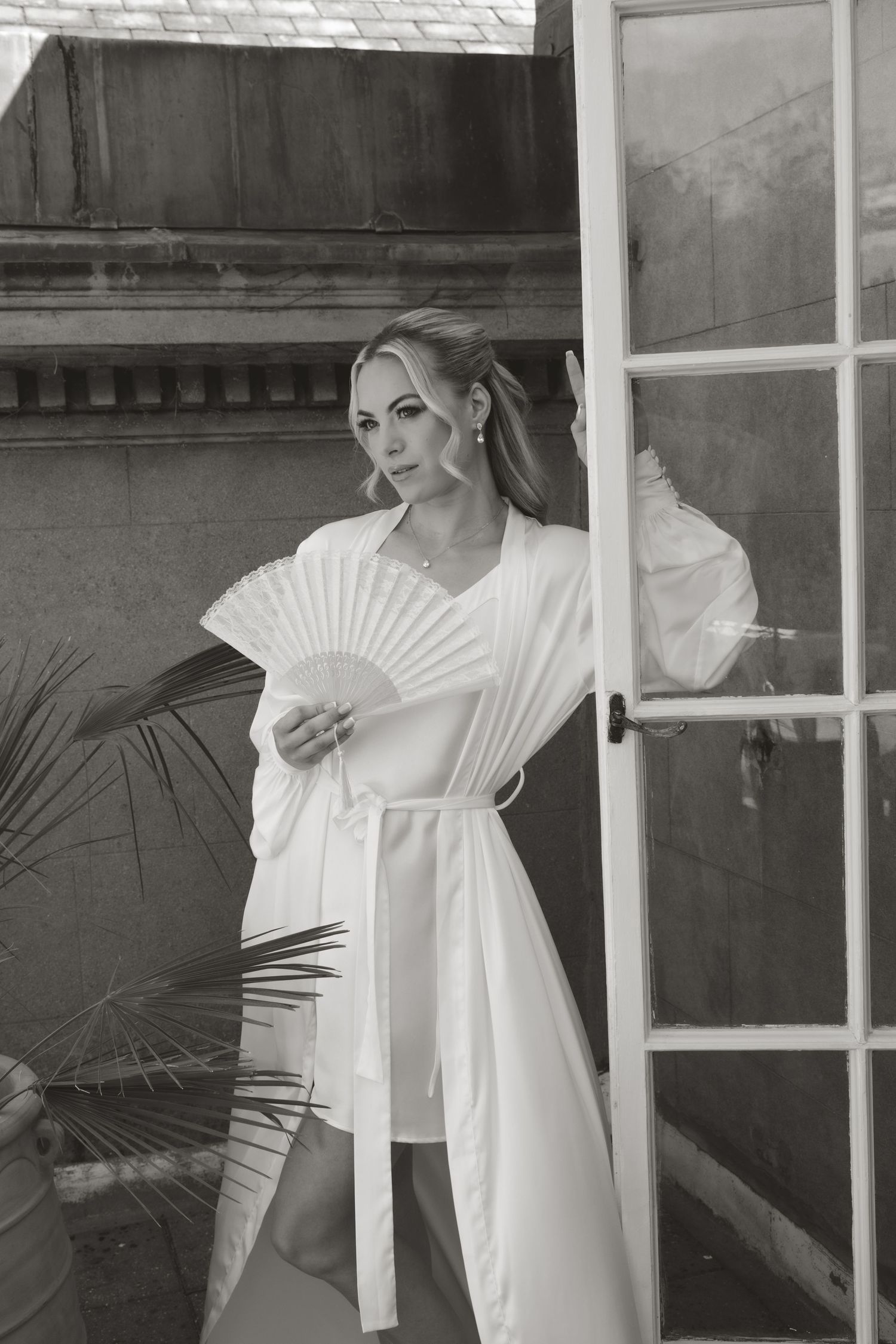 Artistic black and white portrait series featuring white clothing and window reflections.