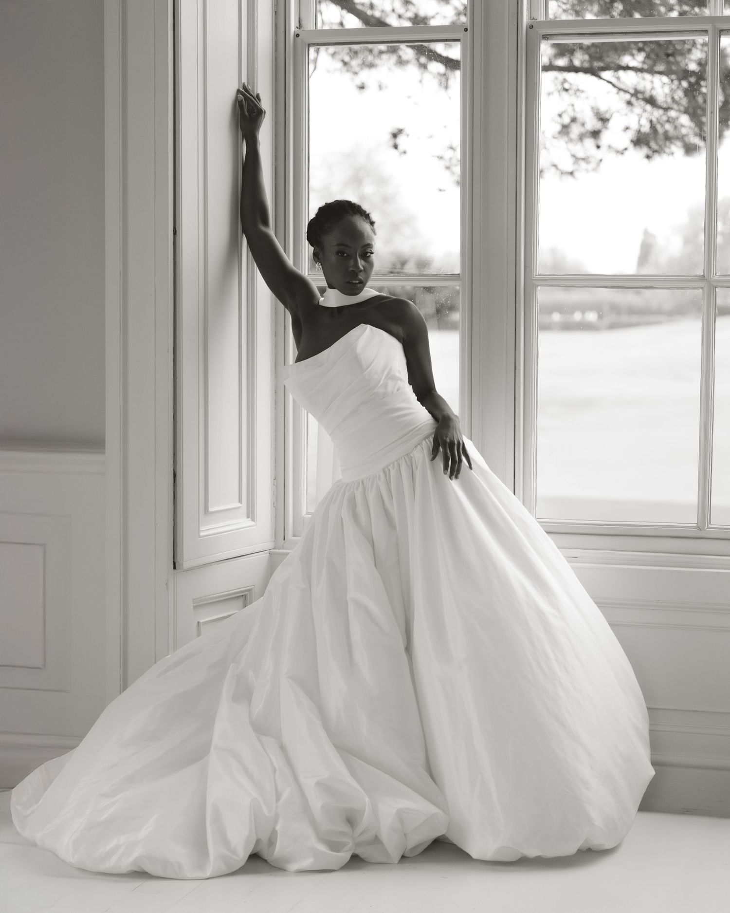 Artistic series of a flowing white wedding dress against bright windows in an elegant room.