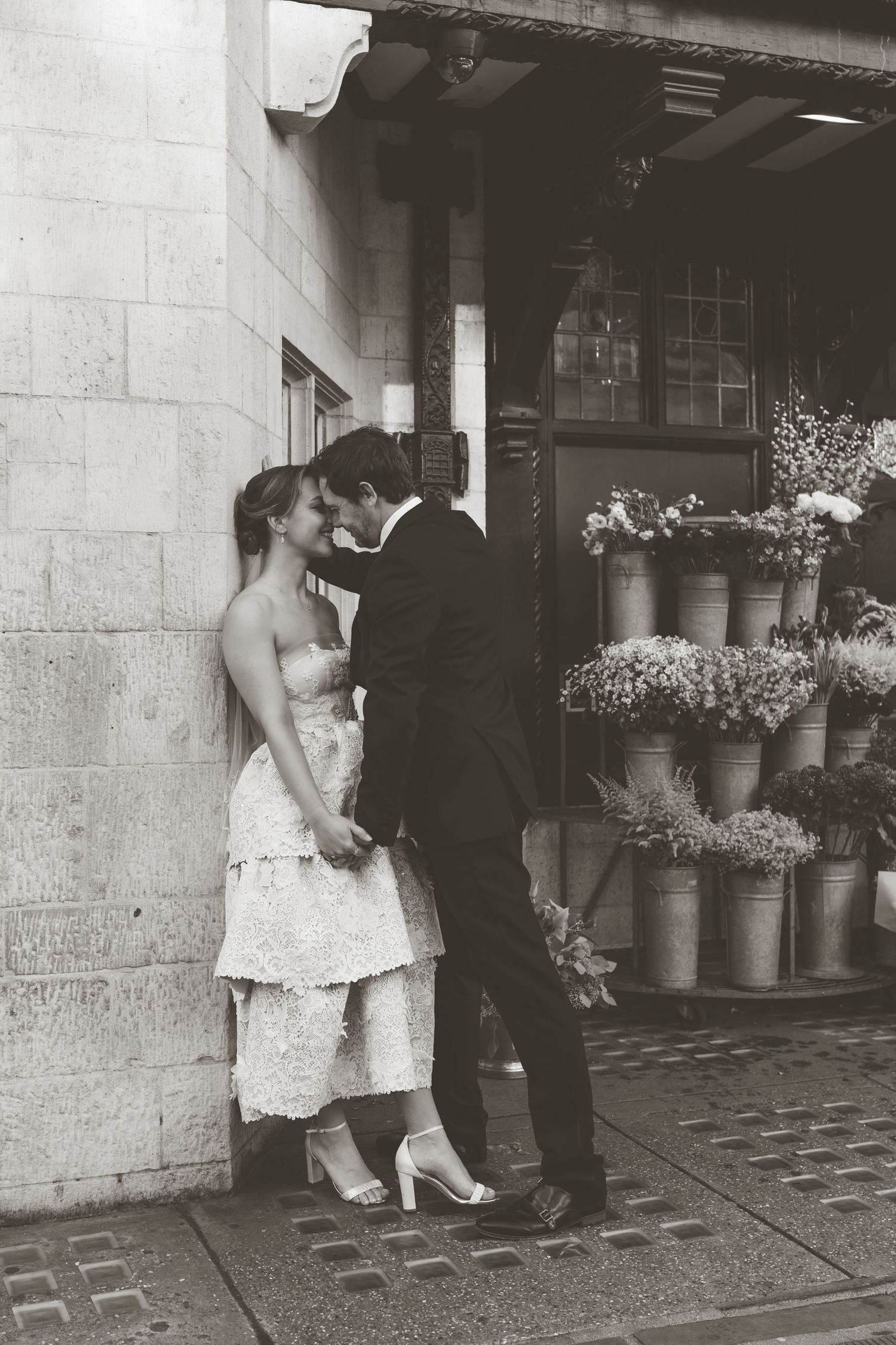Vintage black and white wedding dance photo outside stone building.