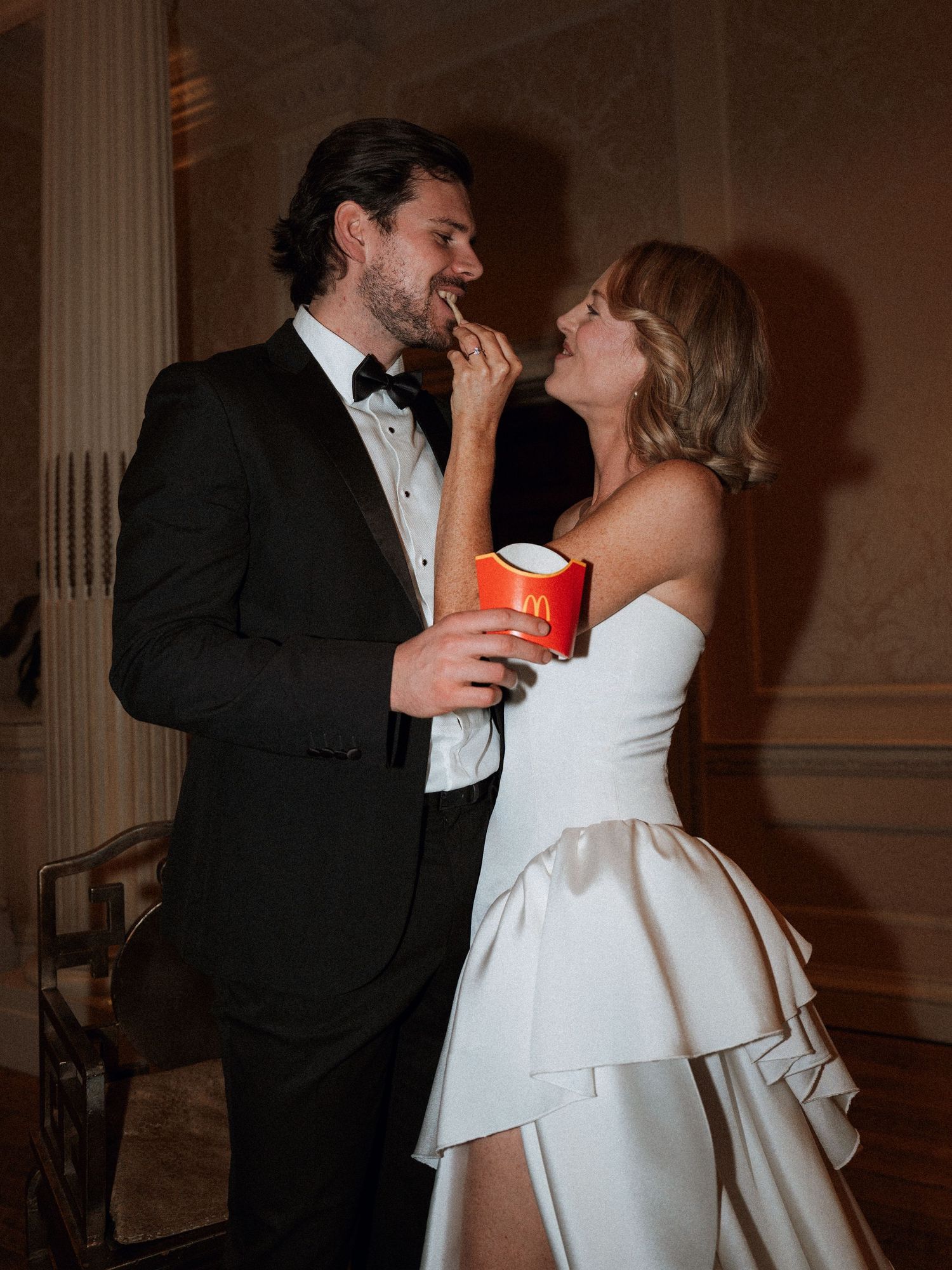 Couple sharing intimate moments during wedding reception in formal attire.