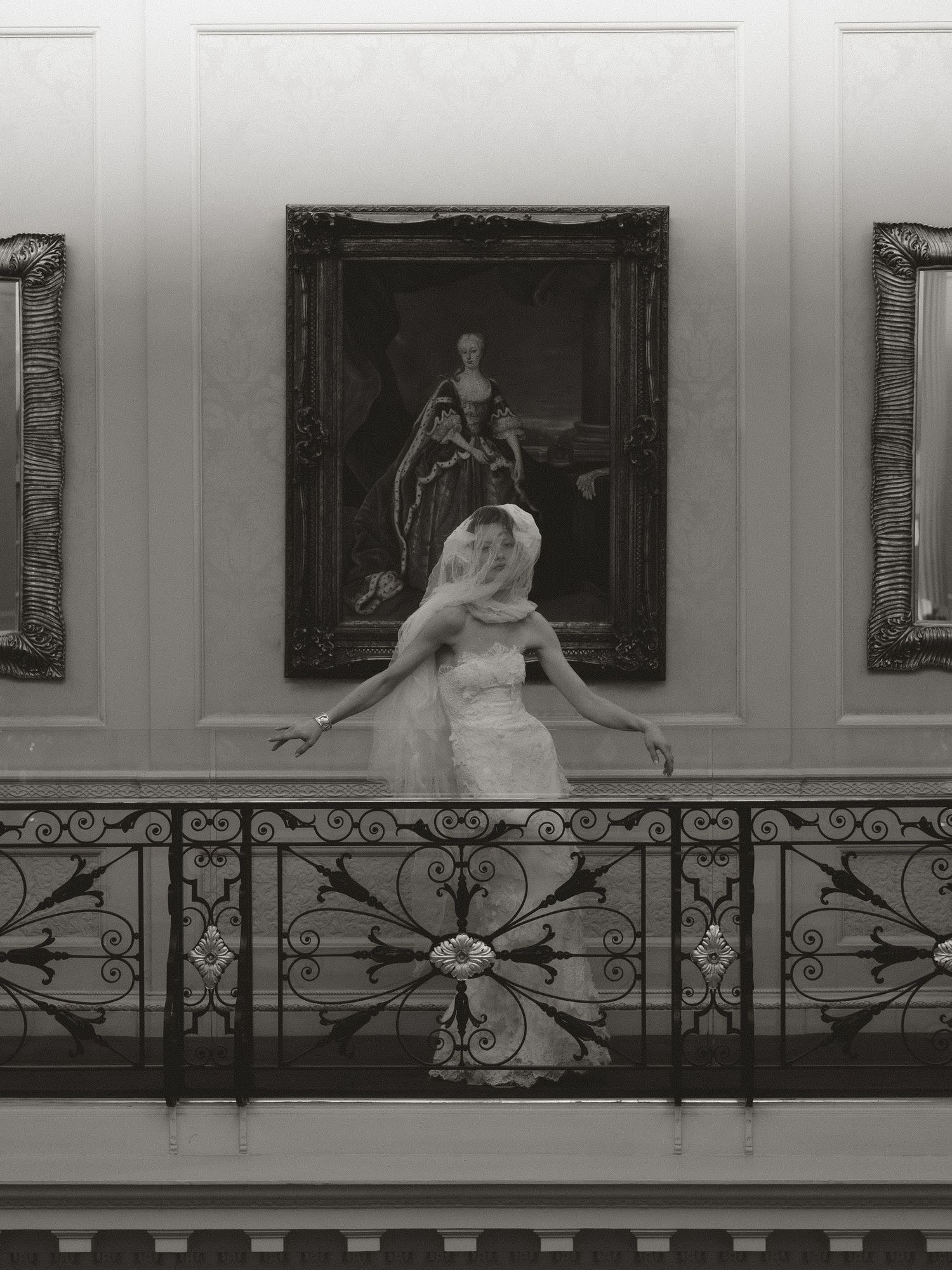 Black and white photo series of a wedding dress against an ornate balcony with artwork.