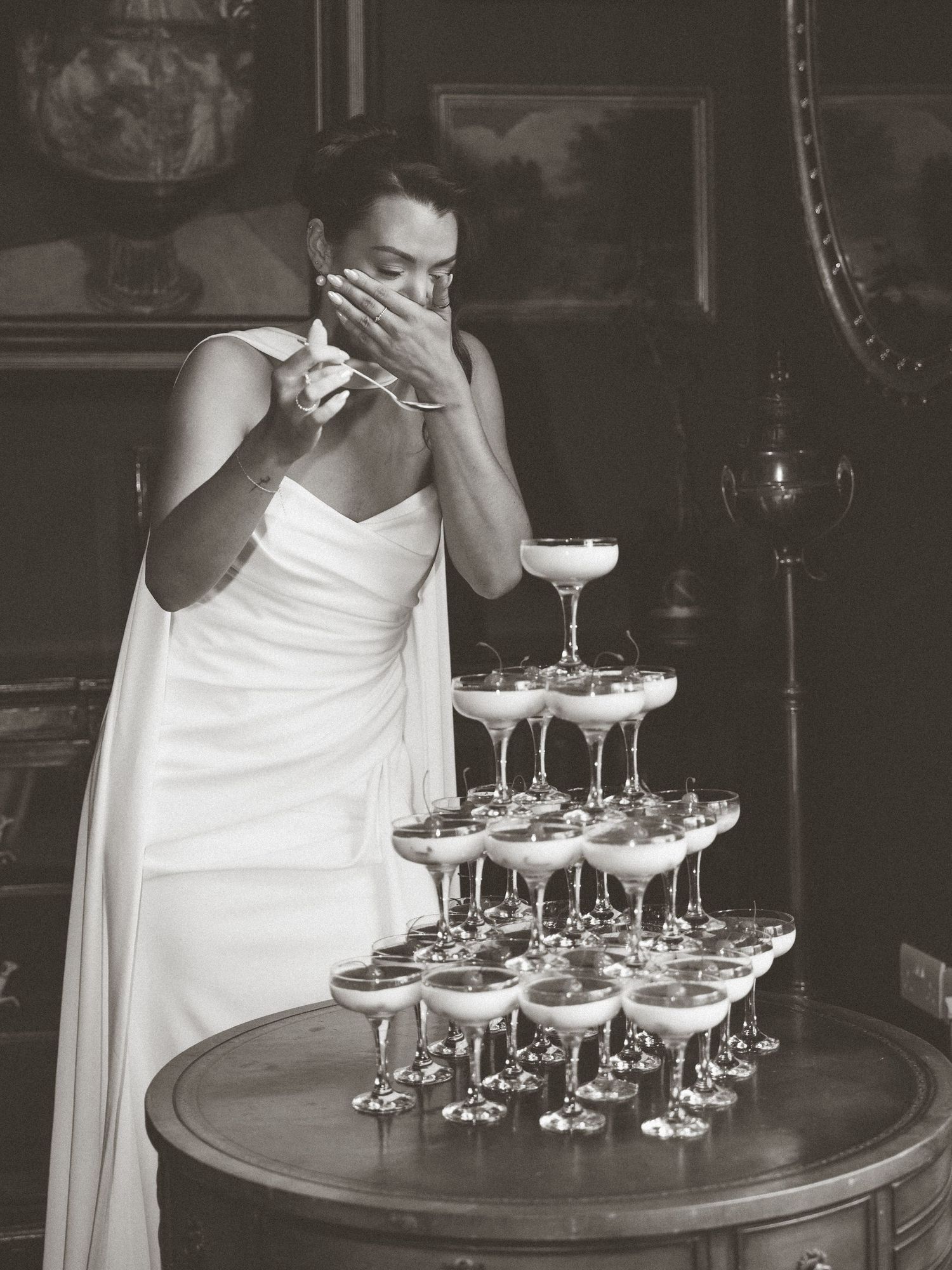 Elegant cocktail glasses arranged on a dark wooden table with white linens.