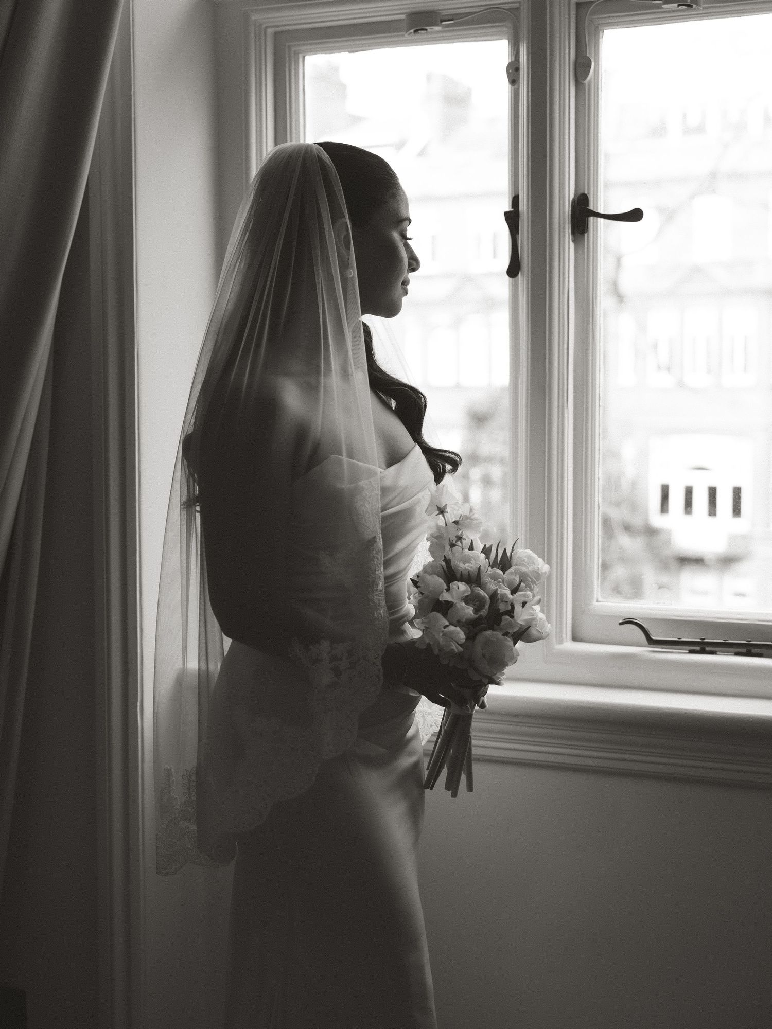 A series of black and white wedding photos showing a bride in silhouette against bright windows.