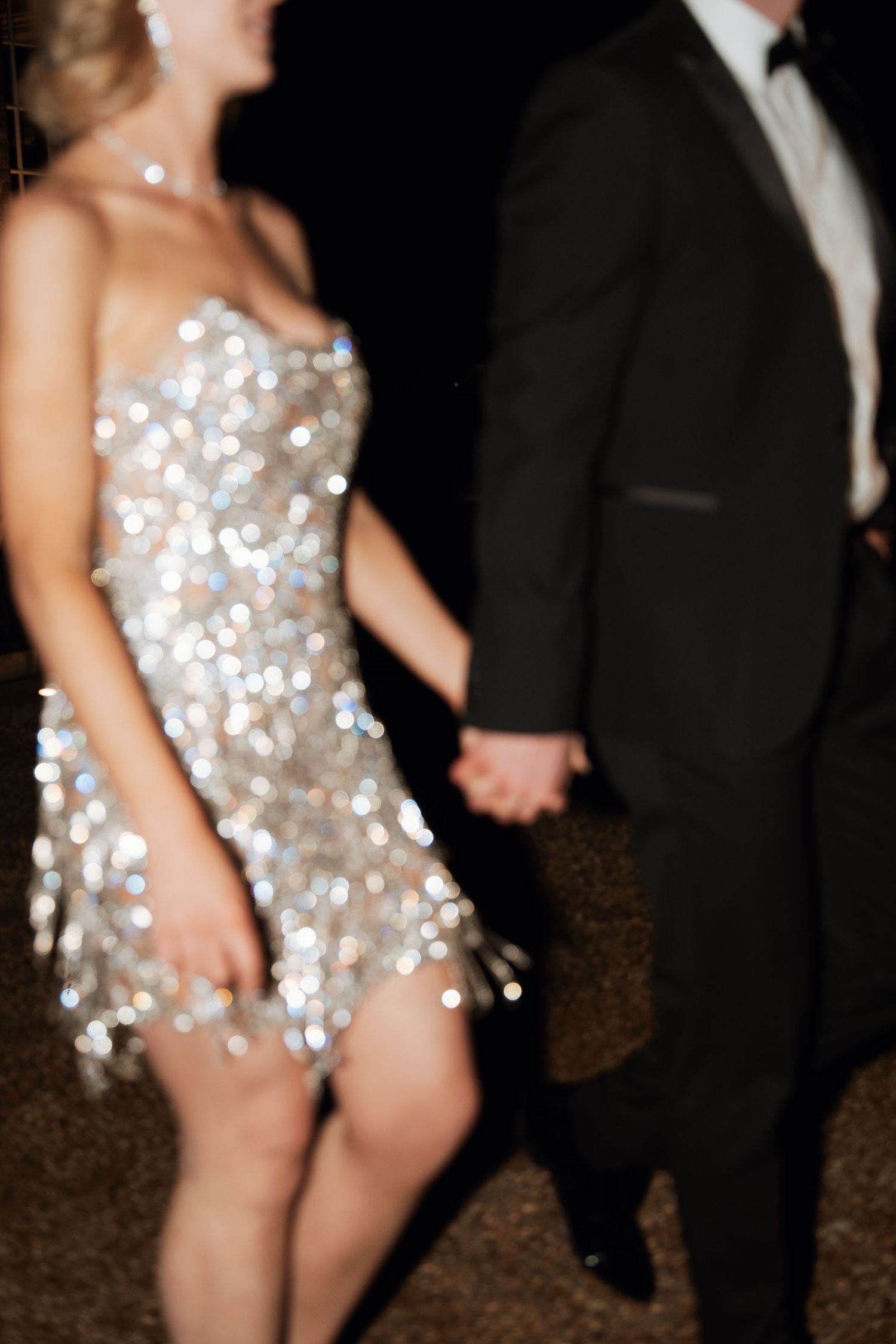 Dancing couple at reception with sparkly dress and formal tuxedo.