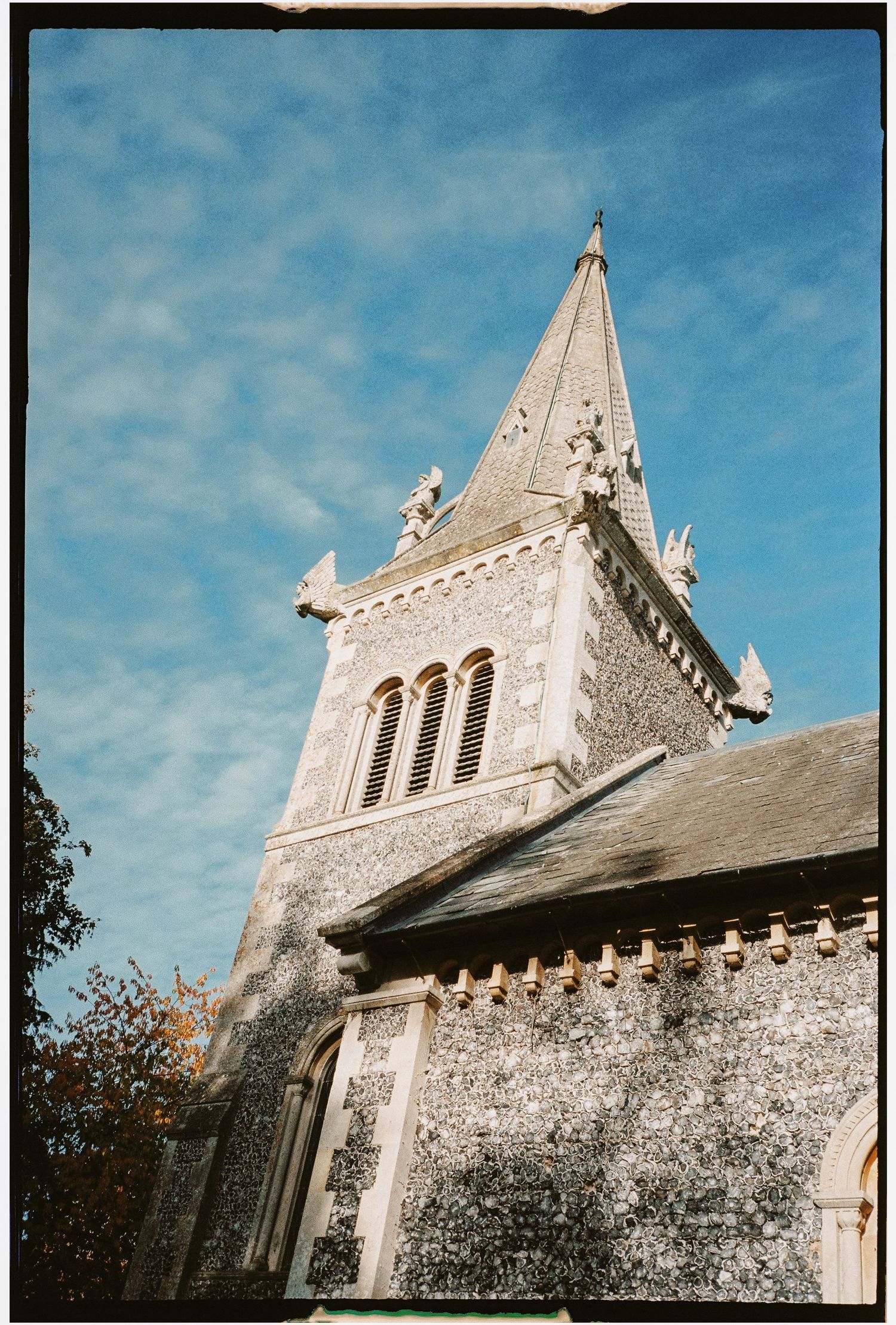 Gothic stone church with ornate spires and architectural details against blue sky.