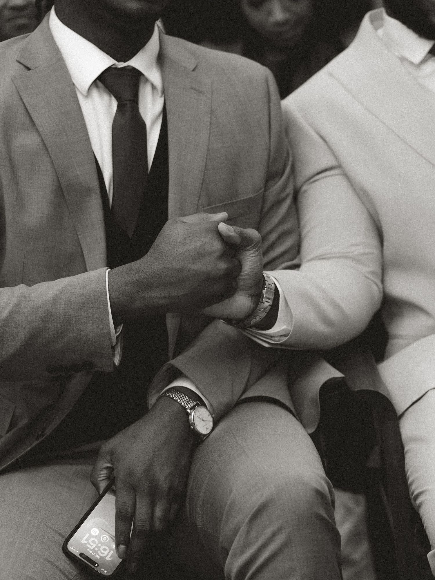 Groomsmen in grey suits seated together during formal wedding party photography.